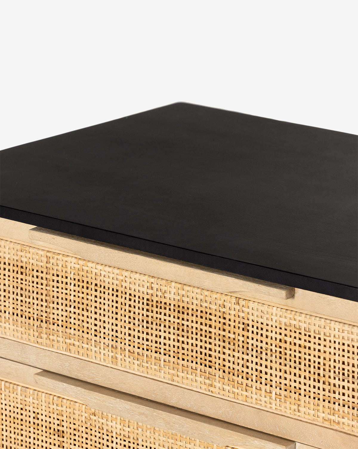 Close-up of the Margaery Nightstand, a minimalist contemporary cabinet with a smooth black top and light wood drawers, featuring a woven cane design, by McGee & Co.