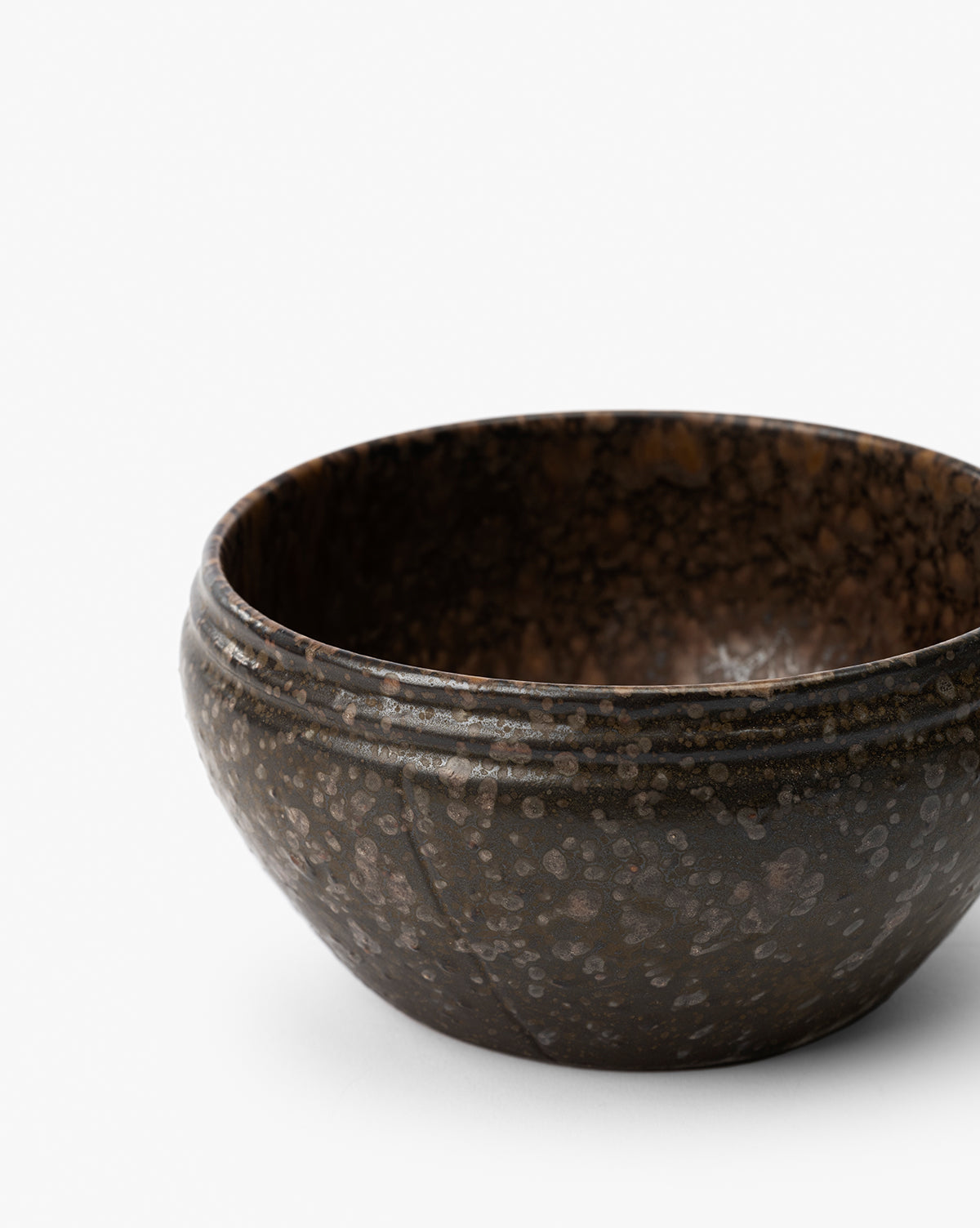 The Mariella Stoneware Bowls (Set of 4) feature a round shape, dark speckled finish, and gently curved rims. Their handmade quality and rustic design offer a simple elegance, perfect for modern or casual table settings by McGee & Co.