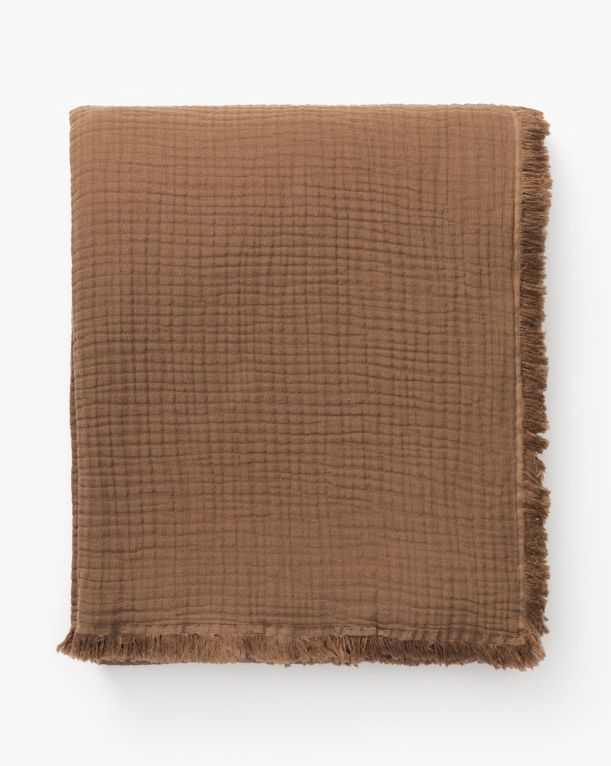The Marinella Oversized Waffle Throw, in folded brown cotton with a subtle grid pattern and fringed edges, displayed against a white background.