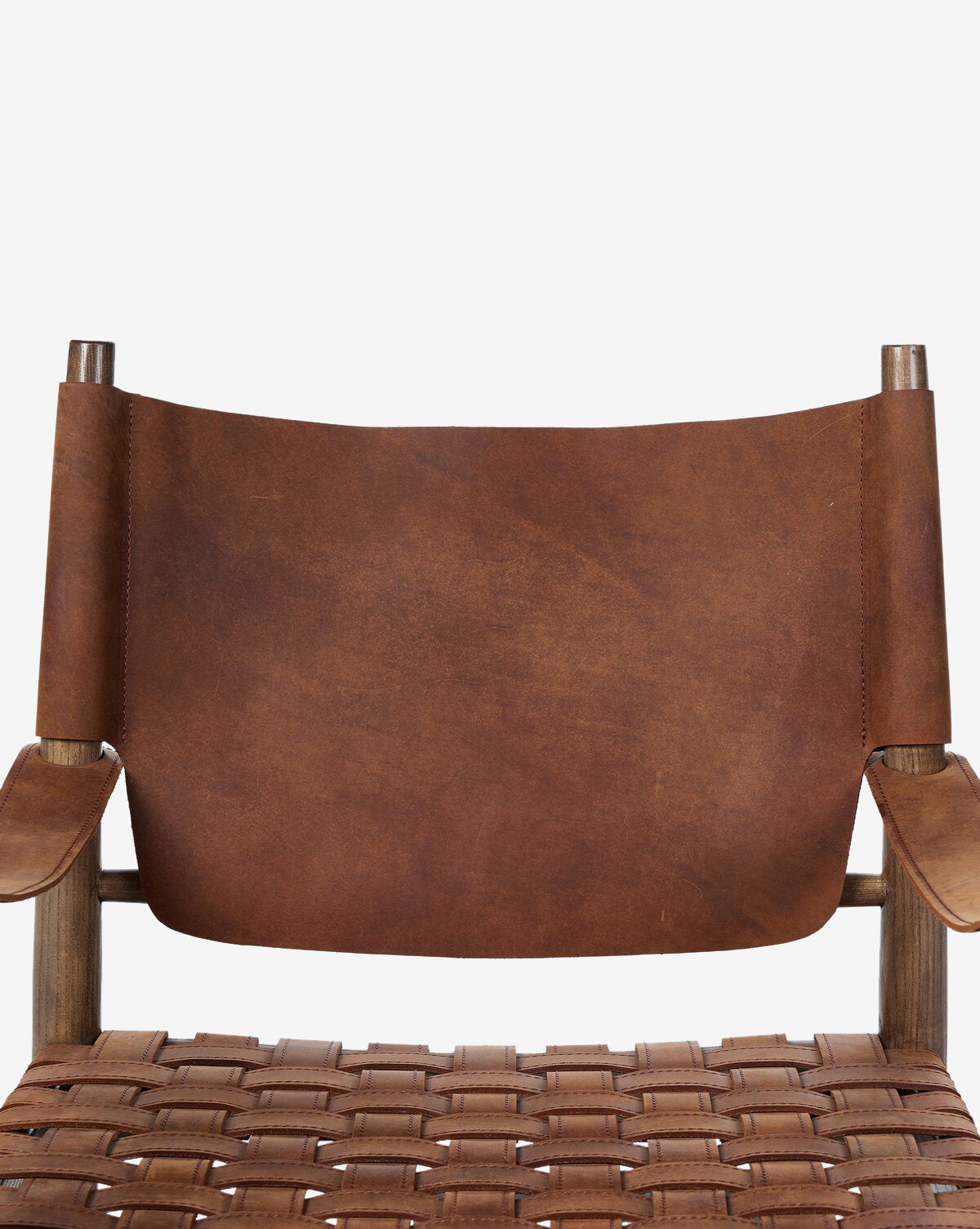 A close-up of the Maris Lounge Chair showcasing its vintage-inspired design, brown top-grain leather backrest, woven leather seat, and sturdy wooden armrests and frame set against a plain white background, by McGee & Co.