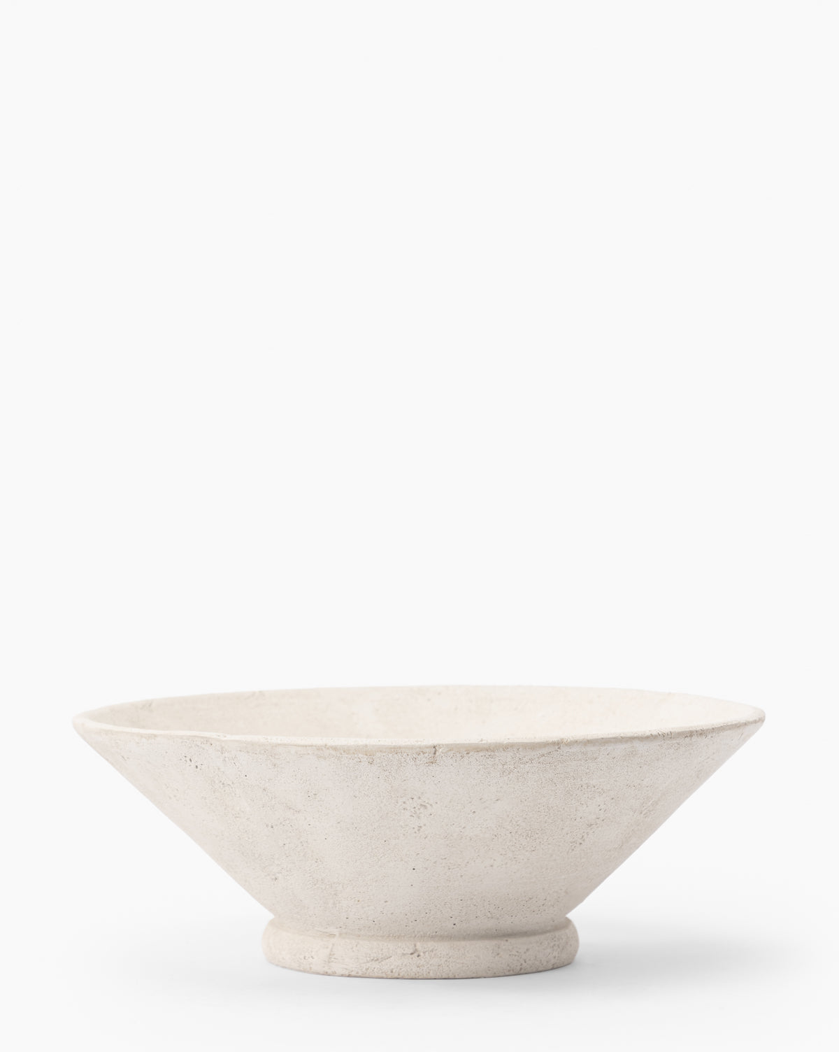 The Matias Bowl features a minimalist, weathered white finish with a wide, shallow shape and small round base, shown against a plain white background.