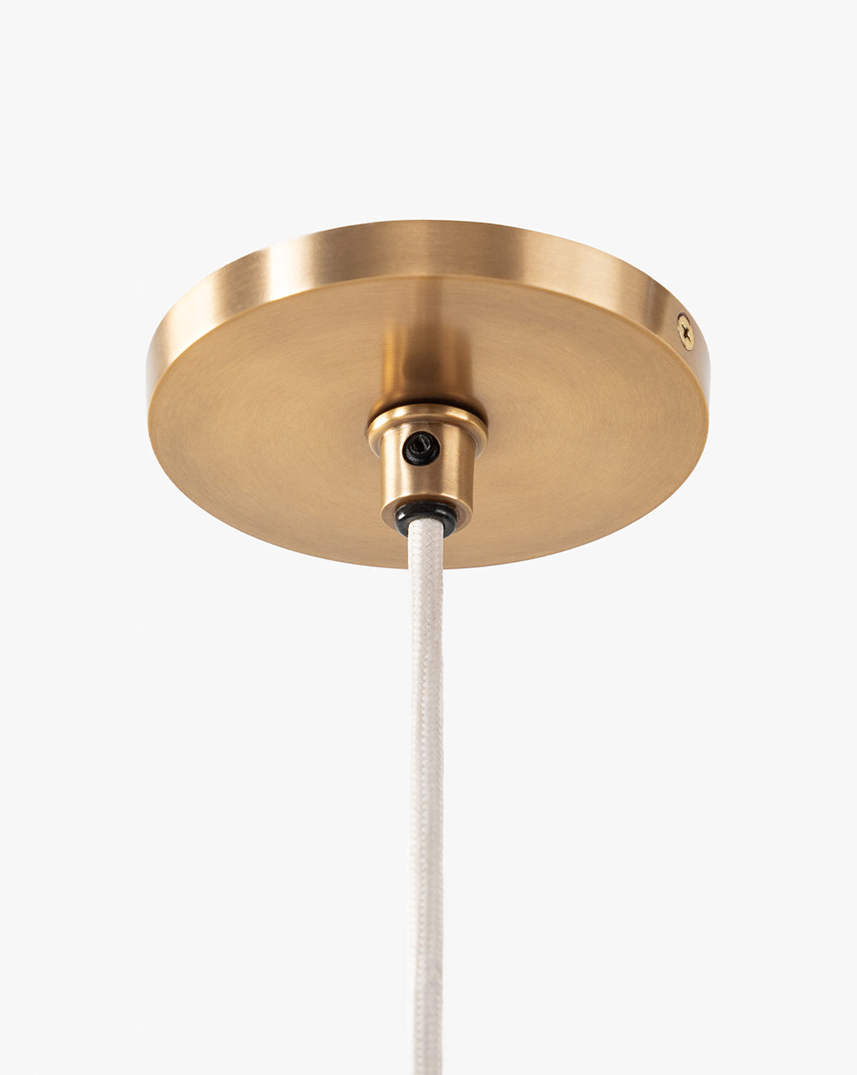 A close-up of a round, brushed brass ceiling canopy with brass hardware and white cord, designed to pair with the McGee & Co. x Loeffler Randall Maude Glass Pendant, shown against a plain white background, by McGee & Co.