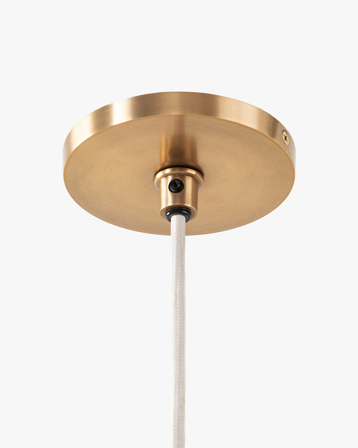 A close-up of a round brass ceiling canopy with a white cord, set against a white background—part of the McGee & Co. x Loeffler Randall Maude Glass Pendant collection, by McGee & Co.