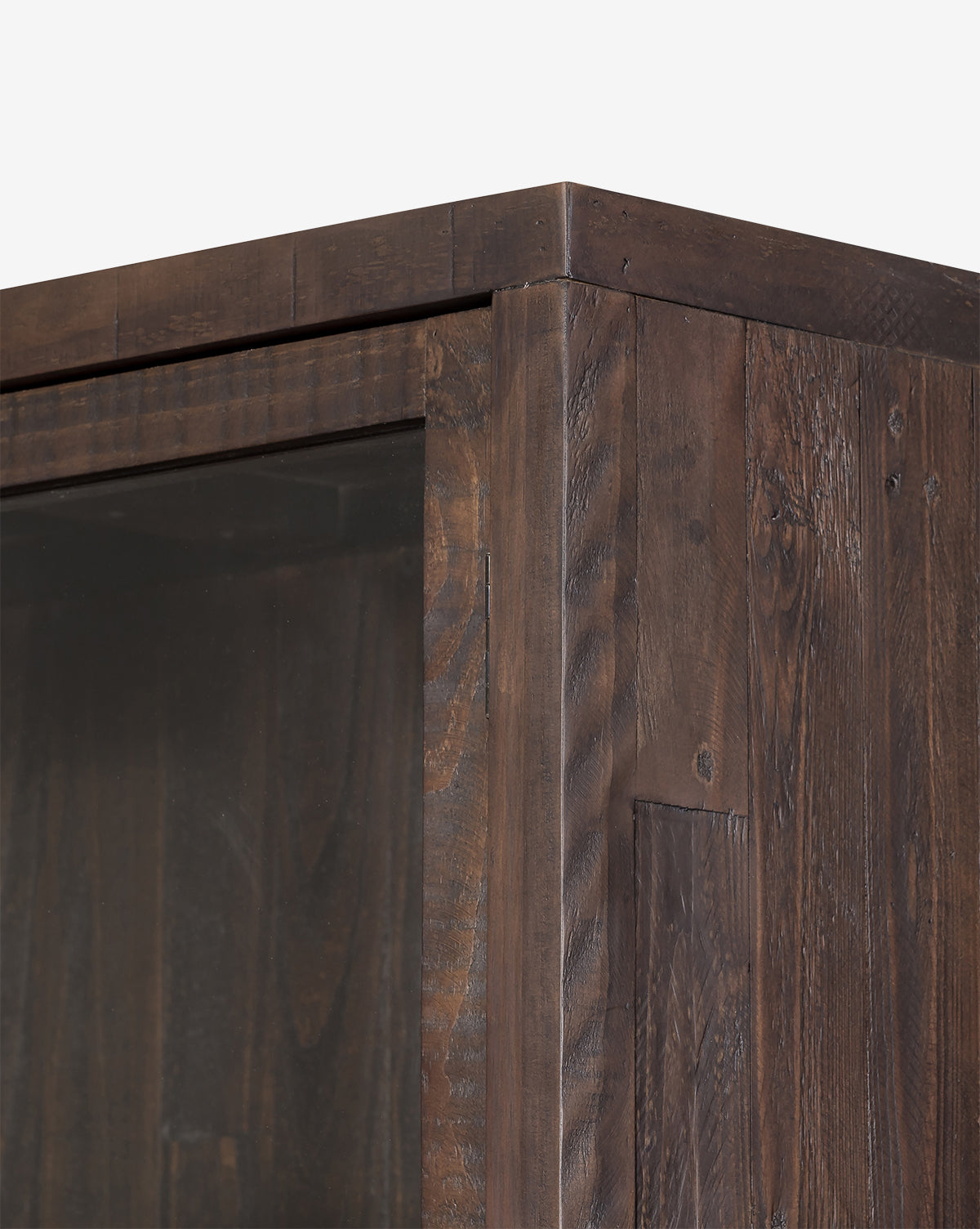 Close-up of the Maverick Cabinets top corner, showcasing its reclaimed pine wood grain, glass paneled doors, iron hardware, and detailed joinery, by McGee & Co.