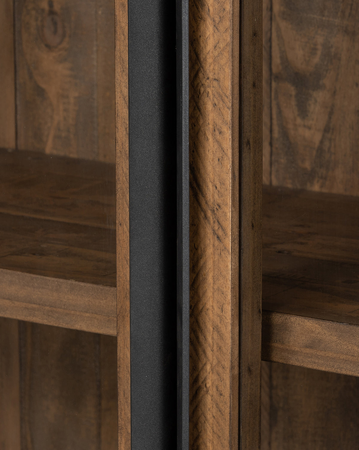 Close-up of the Maverick Cabinet: a wooden shelving unit featuring a vertical black metal support and rustic finish that highlights natural grain and knots. Neatly joined empty shelves evoke the look of reclaimed pine, by McGee & Co.