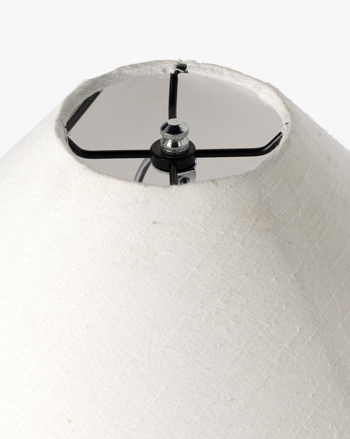 A close-up of the Mays Table Lamp’s white fabric shade highlights its metal frame and central attachment, set against a simple background, by McGee & Co.