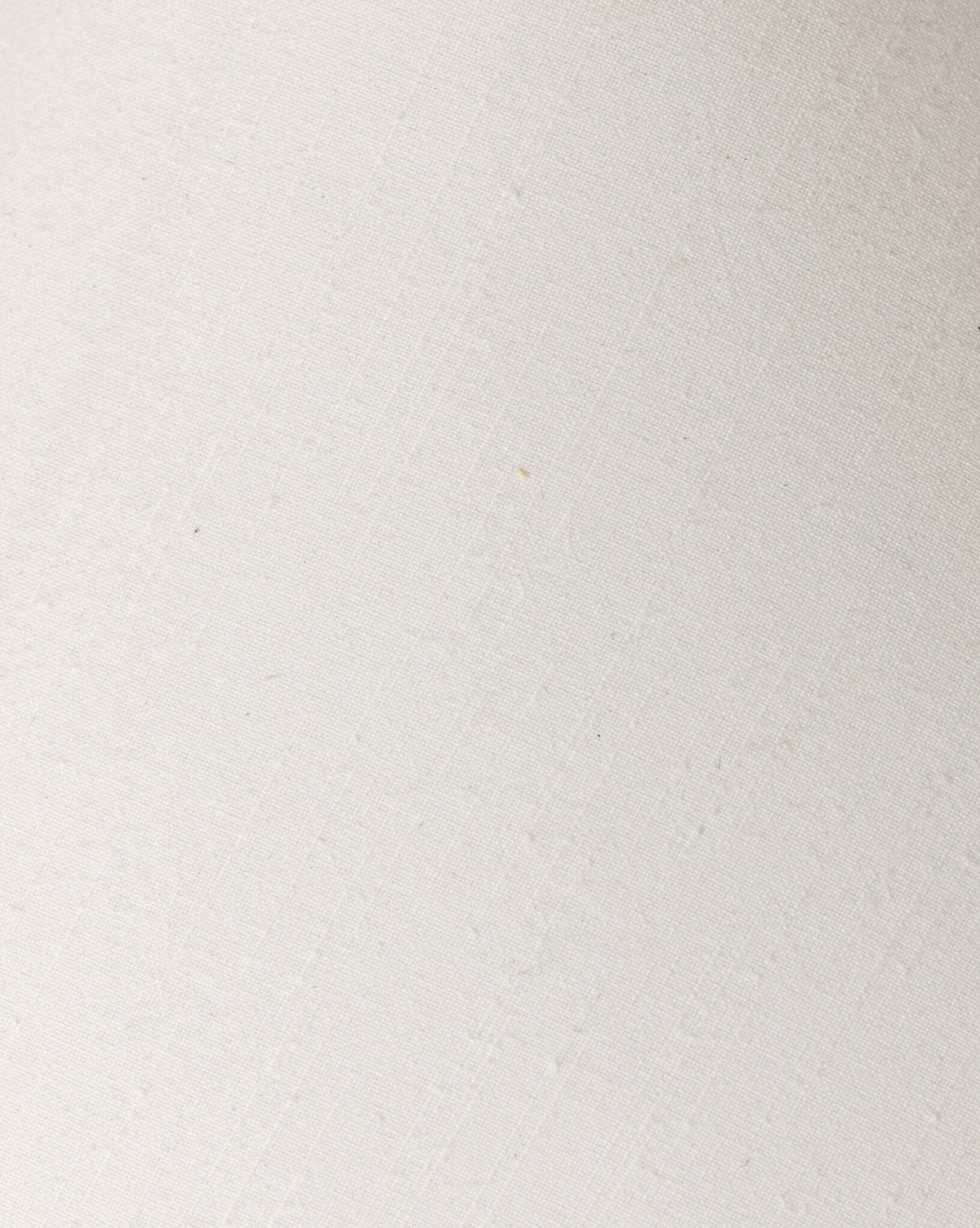 Close-up of the Mays Table Lamp’s textured, off-white surface reveals subtle diagonal lines and slight imperfections, evoking handcrafted details similar to those on a vintage clay jar, by McGee & Co.