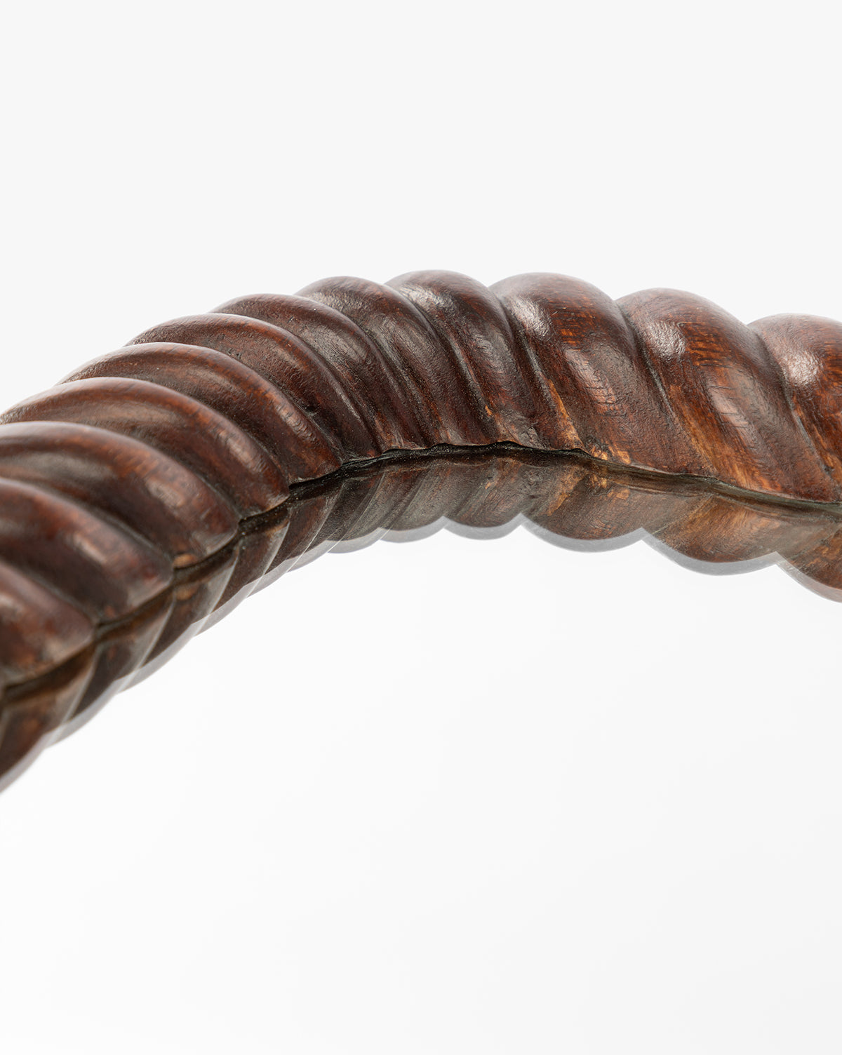 Close-up of the Mayweather Shelf Mirror’s twisted, rope-inspired frame in dark red walnut with a smooth, polished finish, curving elegantly across a white background, by McGee & Co.