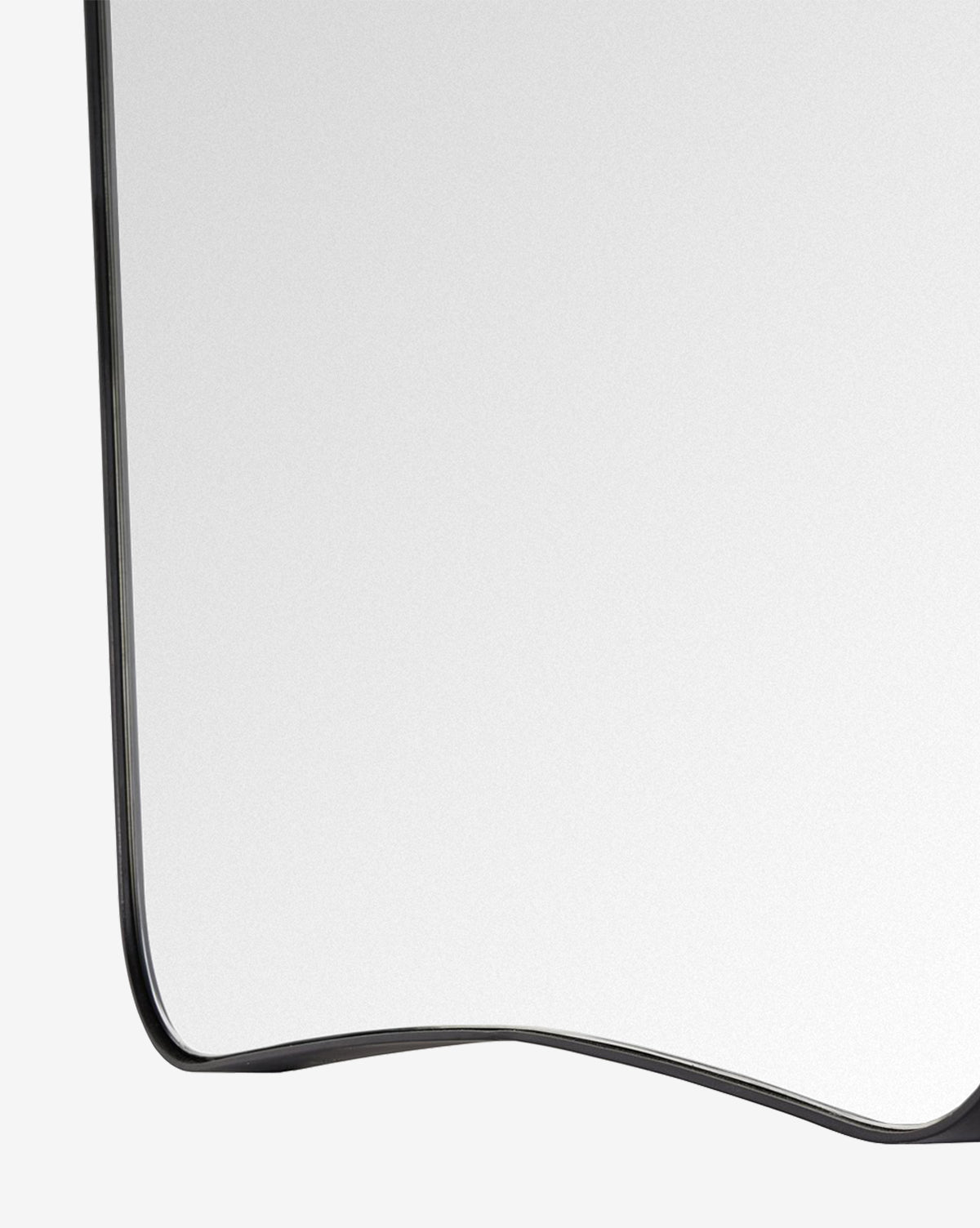 A close-up of the Meera Iron Mirror’s modern iron frame, featuring just the bottom left corner against a plain light background, by McGee & Co.