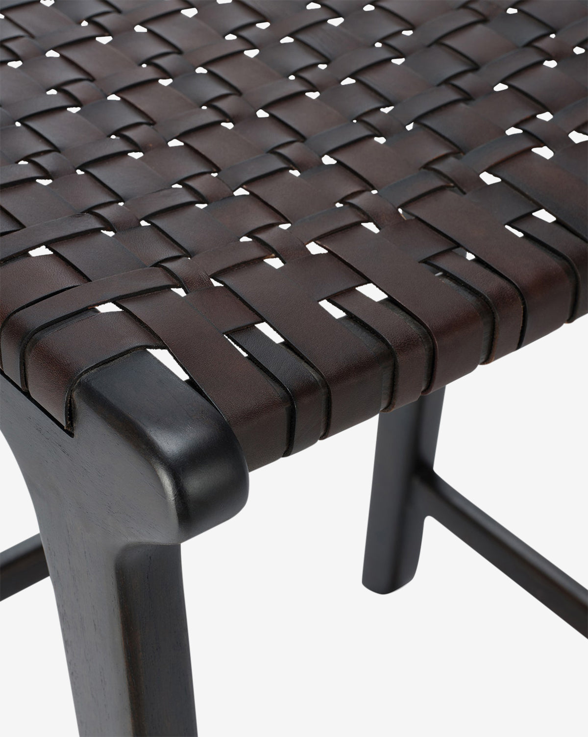 Certainly! Here’s your blended sentence: Close-up of the Meliora Counter Stool by Made Goods, showing dark brown leather straps woven in a crisscross pattern over a teak frame, emphasizing its texture and craftsmanship—McGee & Co.