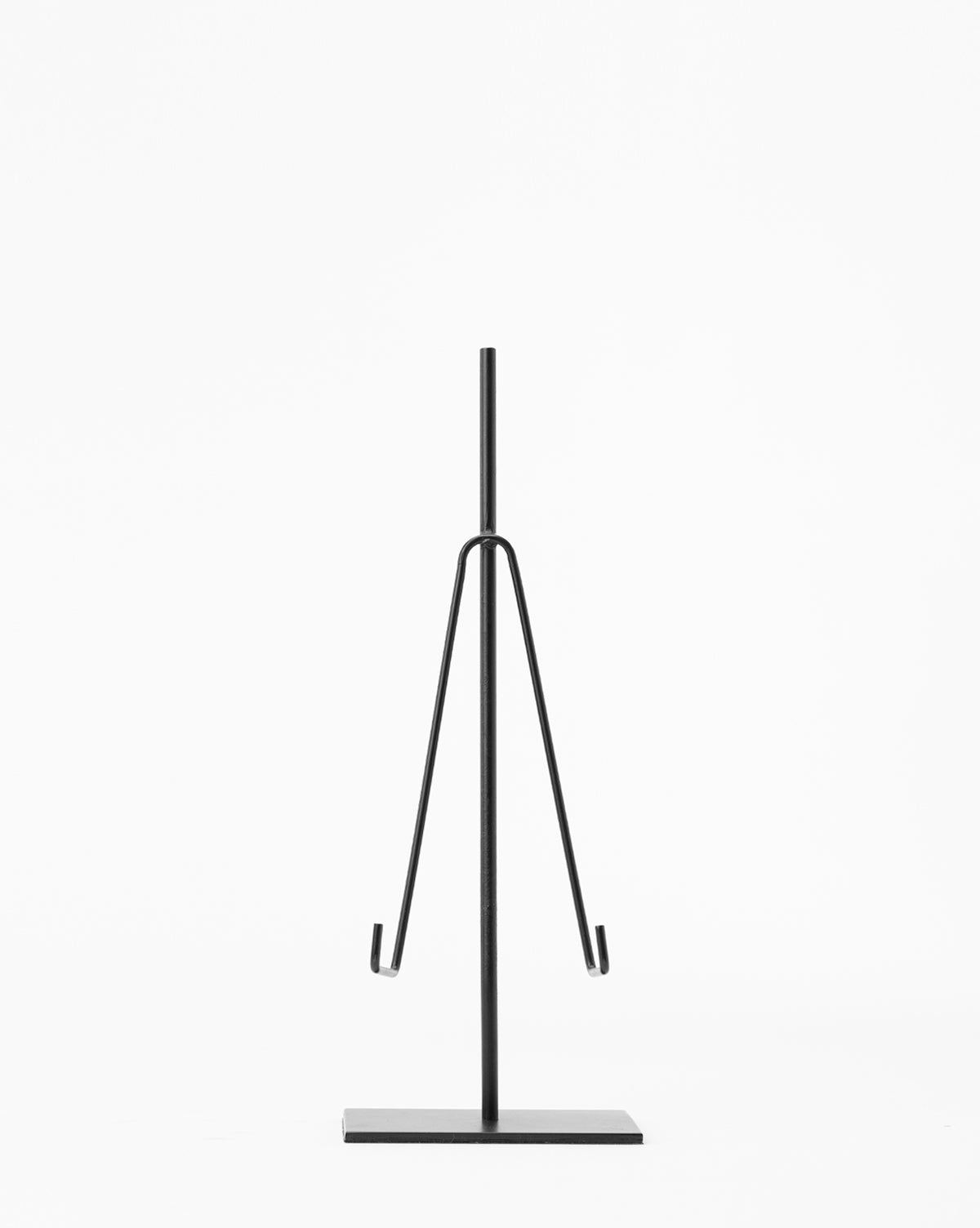 The Metal Easel features a minimalist black metal design with a vertical pole, two angled arms, and a flat rectangular base—ideal for art display or decor—shown against a plain white background.