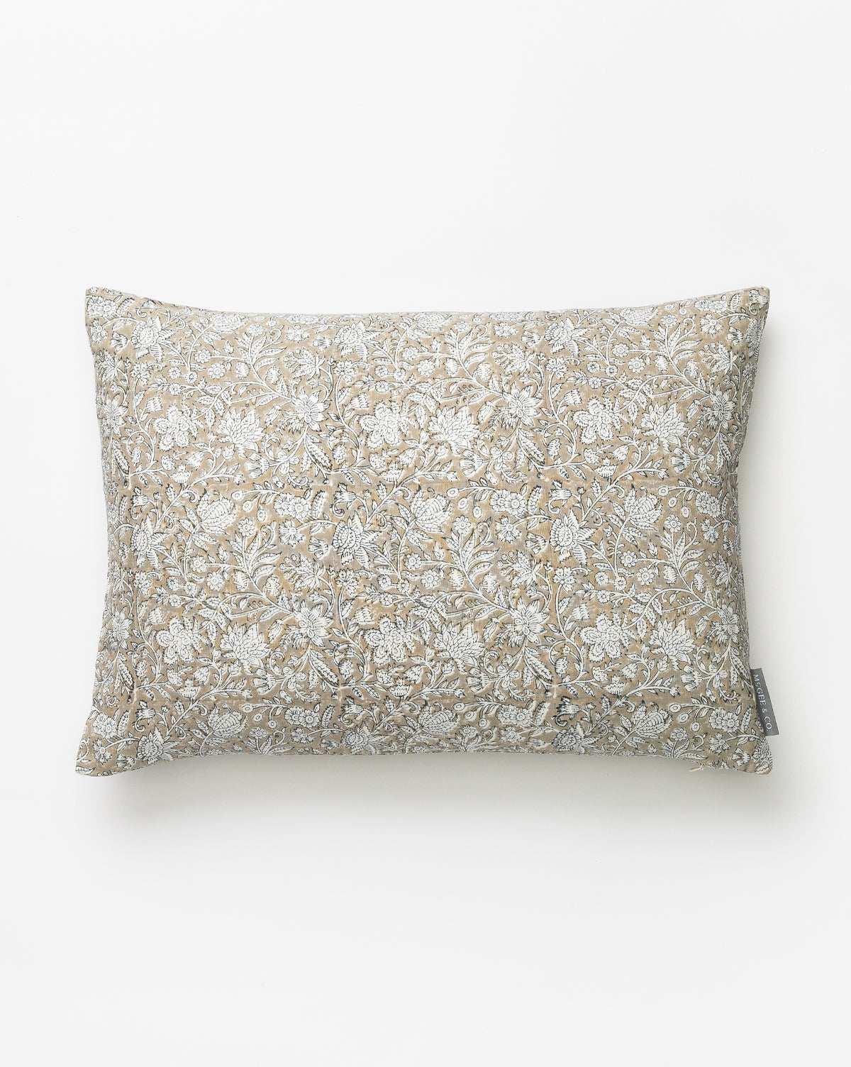 The Mira Pillow Cover features a rectangular, beige and white floral block-print design on a plain white background, complete with an attached fabric tag for added detail, by McGee & Co.