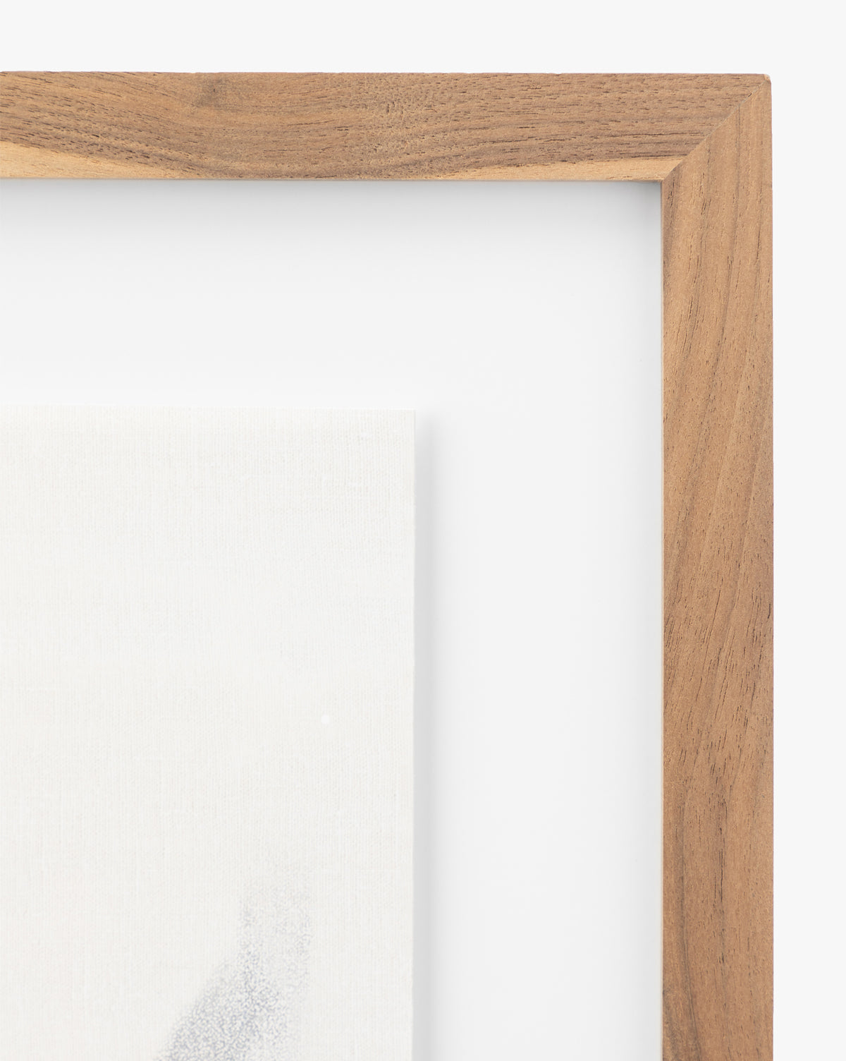 Close-up of the top right corner of a rustic walnut frame with a white mat, featuring the partially visible abstract art giclee print Momento II by Coup dEsprit inside.