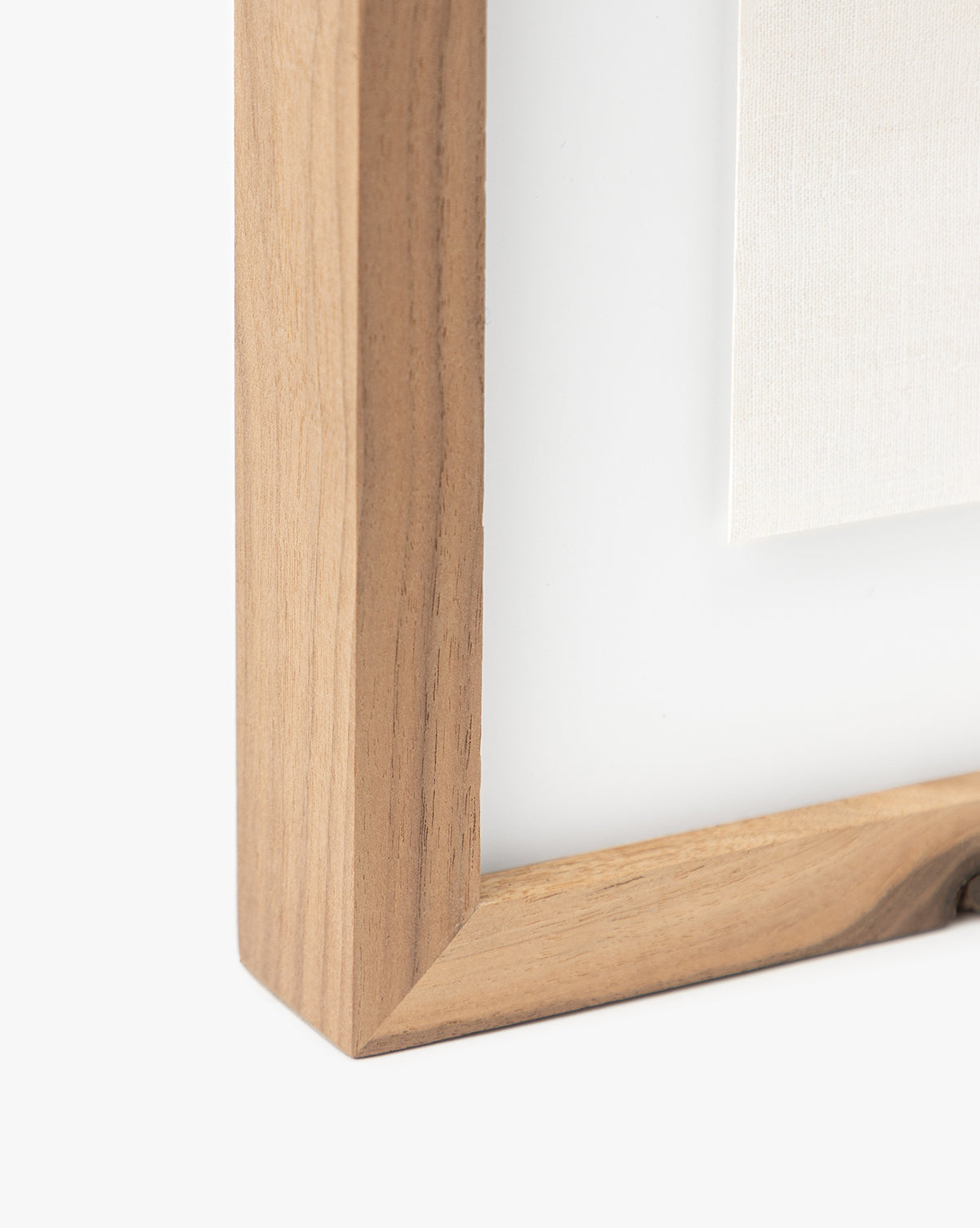 Close-up of the corner of a light wooden frame holding Momento II by Coup dEsprit, with a section of the canvas giclee print visible against a white background.