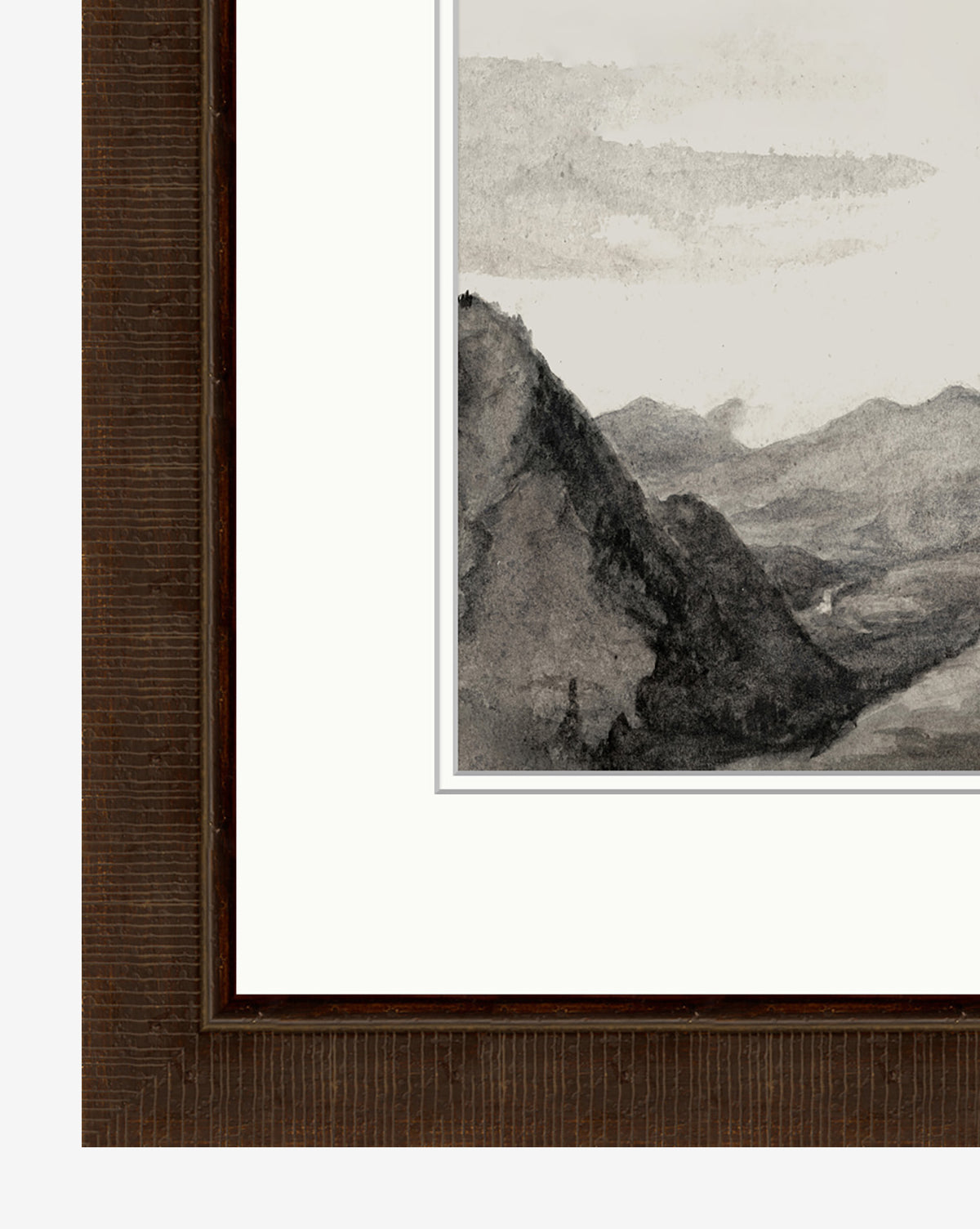 Close-up of the Monochrome Mountains giclee print framed in rich espresso wood, highlighting rugged peaks and a distant valley; only part of the artwork and frame are visible.