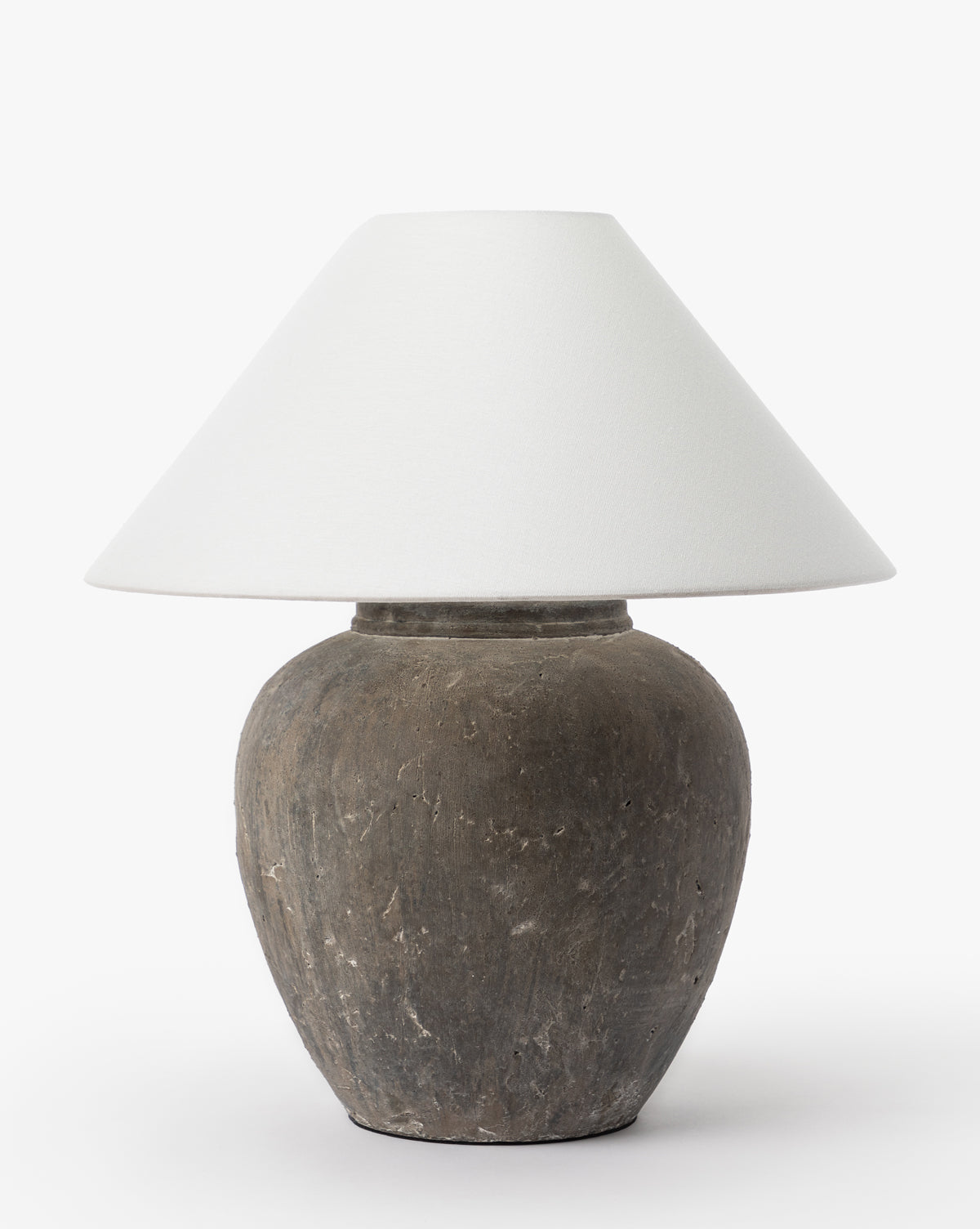 The Montague Table Lamp features a rounded, textured gray ceramic base and a wide, white conical shade, standing out against a plain white background by McGee & Co.