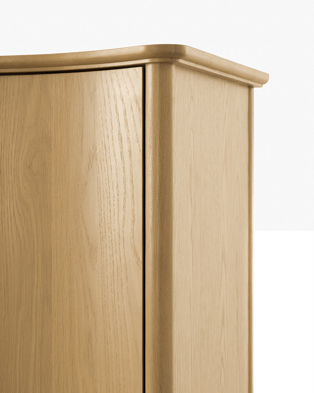 Close-up of the top corner of a Moorland Cabinet, featuring smooth edges, subtle wood grain texture, and a clean, minimalist design—perfect for modern living room storage against a plain background by McGee & Co.