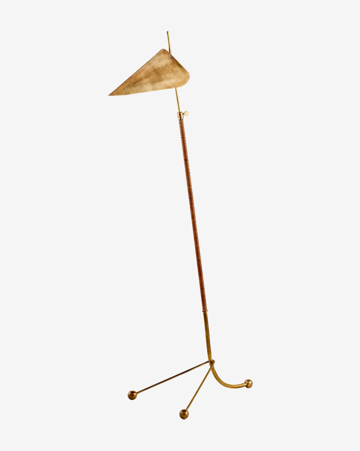 The Moresby Floor Lamp by Visual Comfort & Co. Signature features a minimalist gold stand angled upward, a triangular beige lampshade, and a tripod base with three small gold spheres—McGee & Co.