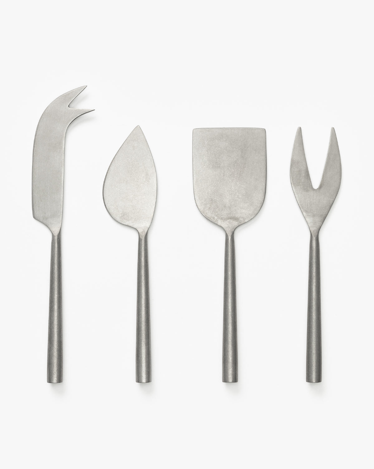 The Mortensen Cheese Knives (Set of 4) features stainless steel, modern-design knives—fork-tipped, pointed, flat rectangular, and two-pronged—displayed in a row on a white background by McGee & Co.