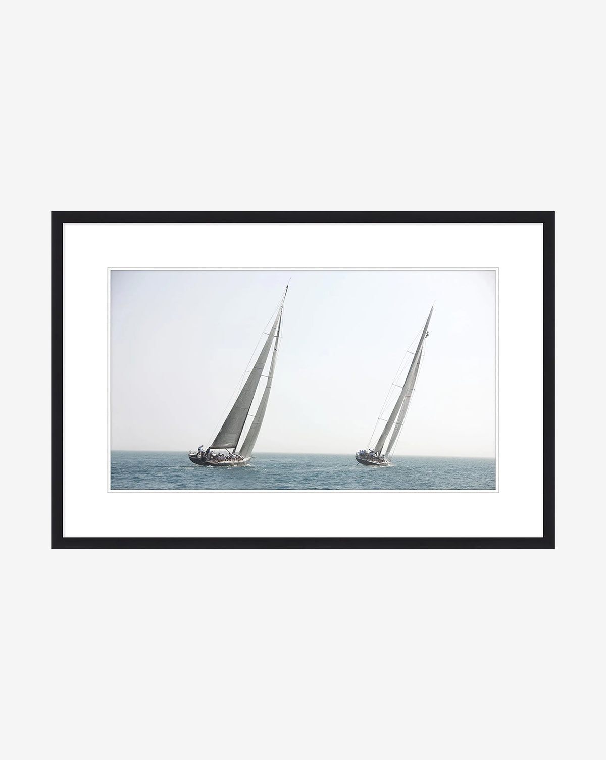 Motion is a framed giclee print of two sailboats with tall sails drifting on calm blue water under a clear sky—ideal sailboat wall art for adding coastal charm to your home decor, by McGee & Co.