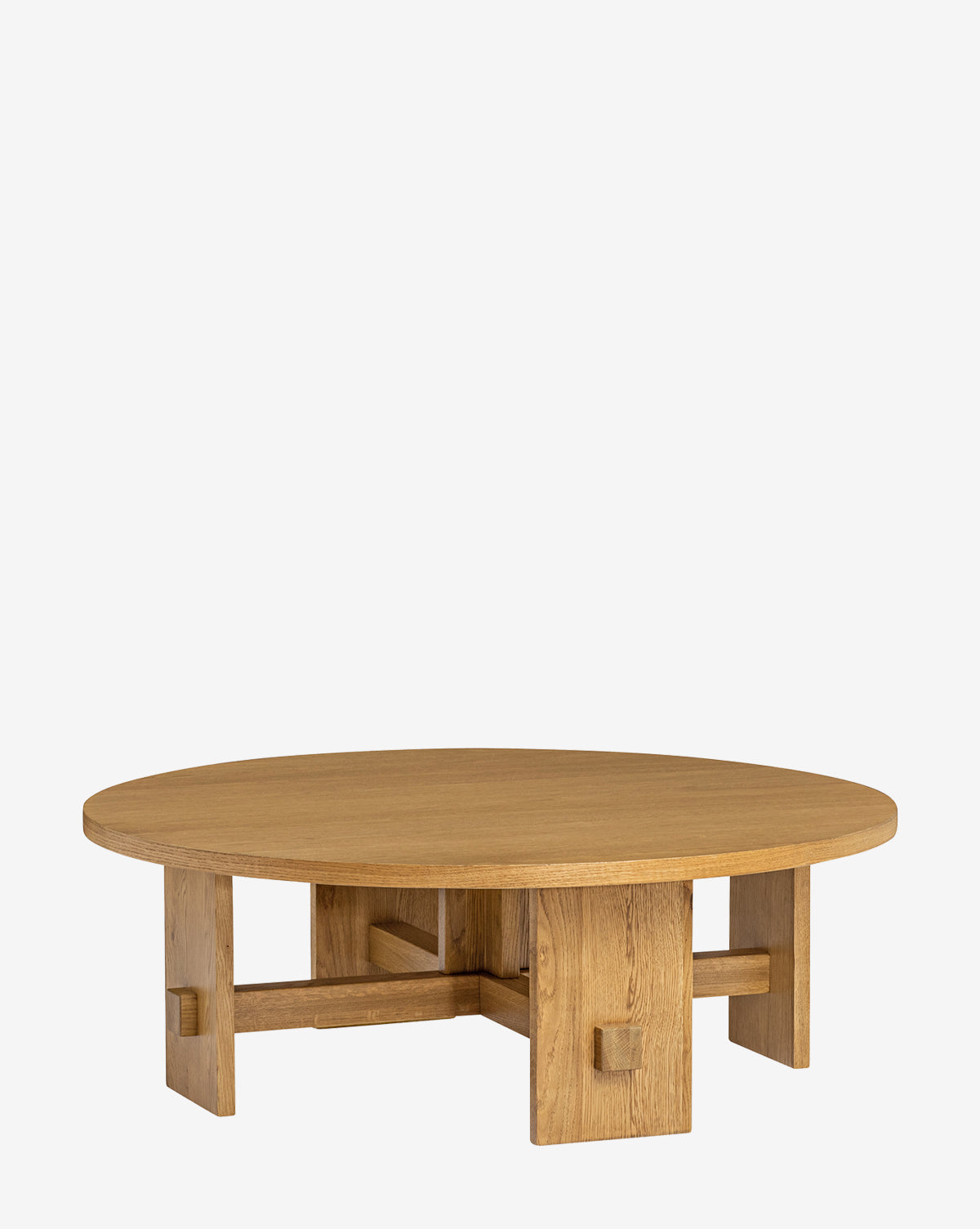 The Newbold Coffee Table is a round oak table with a natural finish, thick tabletop, and sturdy geometric base featuring intersecting rectangular legs, by McGee & Co.