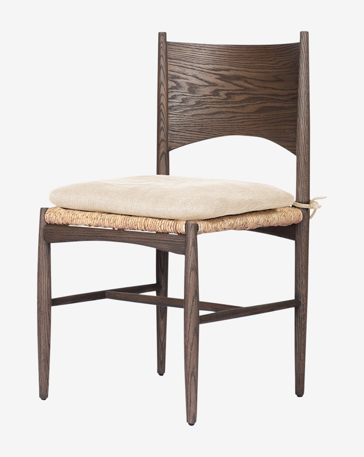 The Nixie Dining Chair features a solid oak frame in dark brown, a woven rush seat, and a light beige tie-on cushion. Its classic design includes a curved backrest and angled legs for timeless appeal, by McGee & Co.