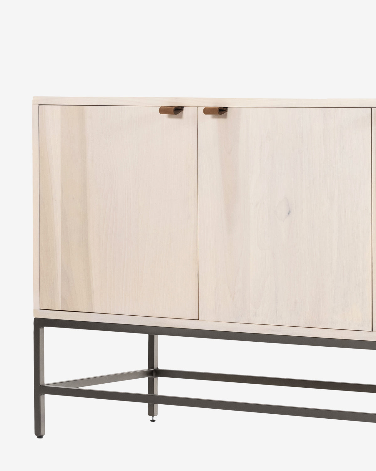 The Noland Sideboard is a modern cabinet with hidden storage behind light wood double doors, minimal handles, and a black metal frame and legs, shown against a white background by McGee & Co.
