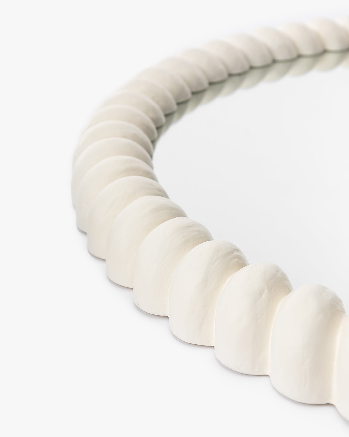 A close-up of the Norina Mirror, a modern mirror with a thick, textured white frame that adds coastal charm to any space, shown against a plain white background, by McGee & Co.