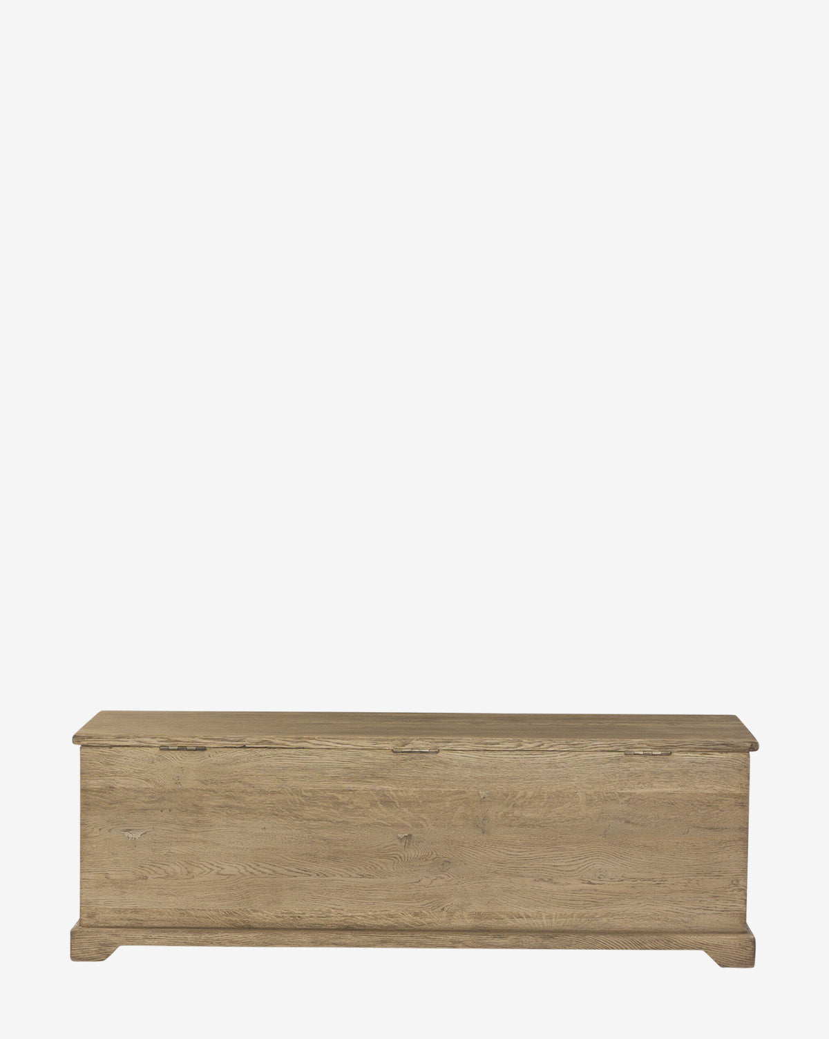 The Norman Bench by Four Hands is a rectangular built-in storage bench with a hinged lid, made from light brown solid oak, functioning as both an entryway bench and storage chest, shown against a plain white background. McGee & Co.