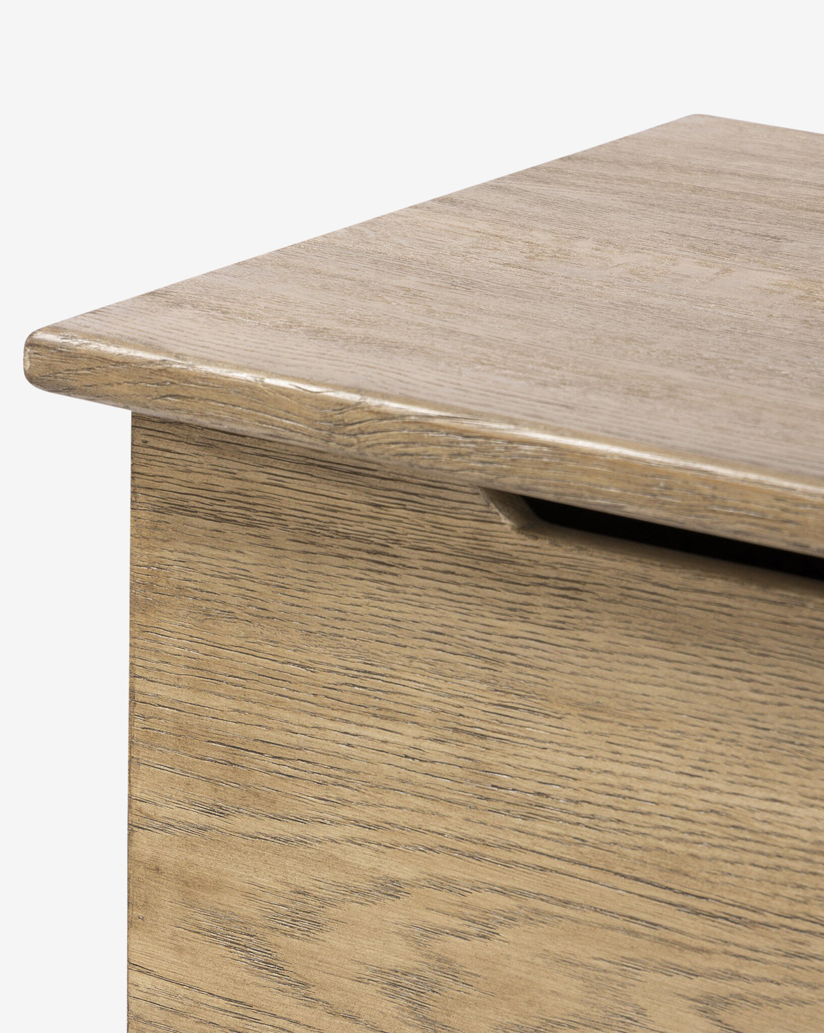Close-up of the Norman Bench by Four Hands, showing the solid oak corner with a smooth, flat lid and a cutout handle beneath the edge for easy access. McGee & Co.