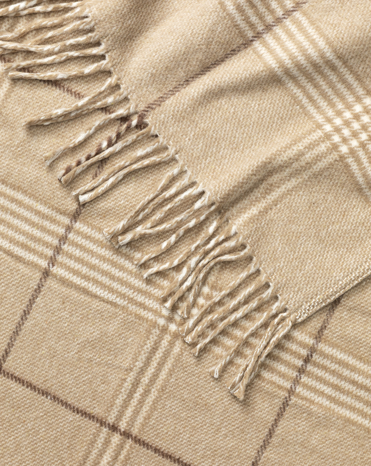 A close-up of the Nottingham Throw by J Call Designs LLC dba Sew Miami LLC, showcasing its beige plaid pattern with fringed edges and intersecting light and dark brown lines for a classic, cozy appearance. McGee & Co.