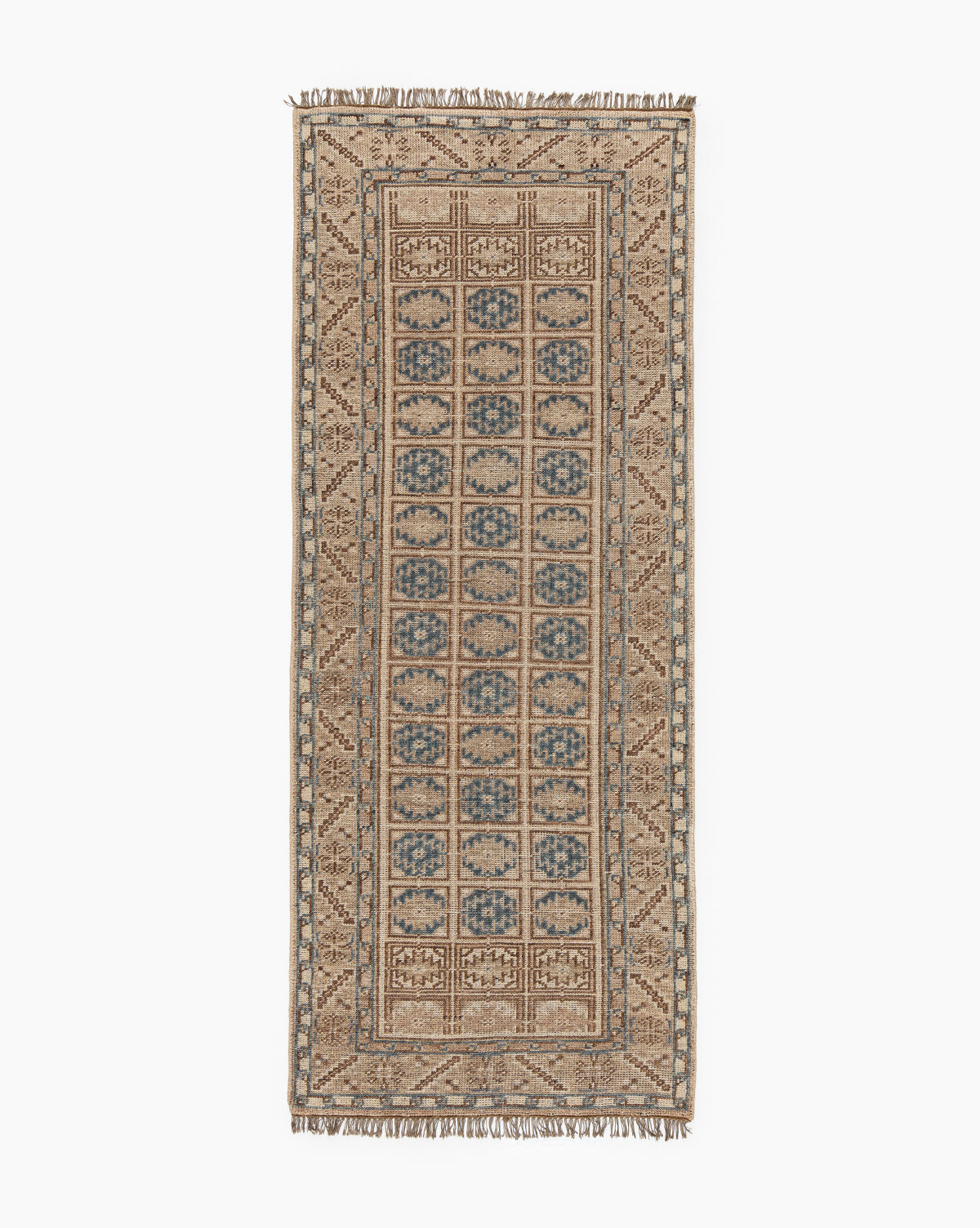 The Nunez Hand-Knotted Wool Rug features a rectangular shape with a beige and light brown border, blue and tan repeating central motifs, and short fringe on both ends for a timeless look, by McGee & Co.