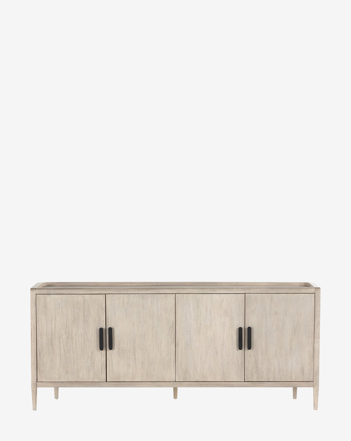 The Nyx Sideboard, featuring four doors, black handles, and short legs in light wood, offers adjustable shelves for versatile storage. Its modern look combines style and function, making it a standout piece against a white backdrop by McGee & Co.