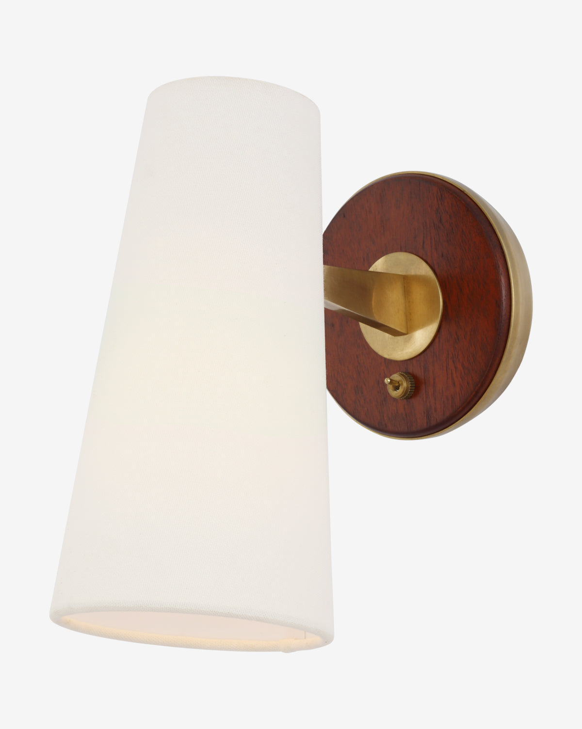 The Olina Sconce by Visual Comfort & Co. Signature is a wall-mounted fixture with a conical white linen shade, brass arm, circular base, dark wood backplate accents, and a small brass switch. McGee & Co.