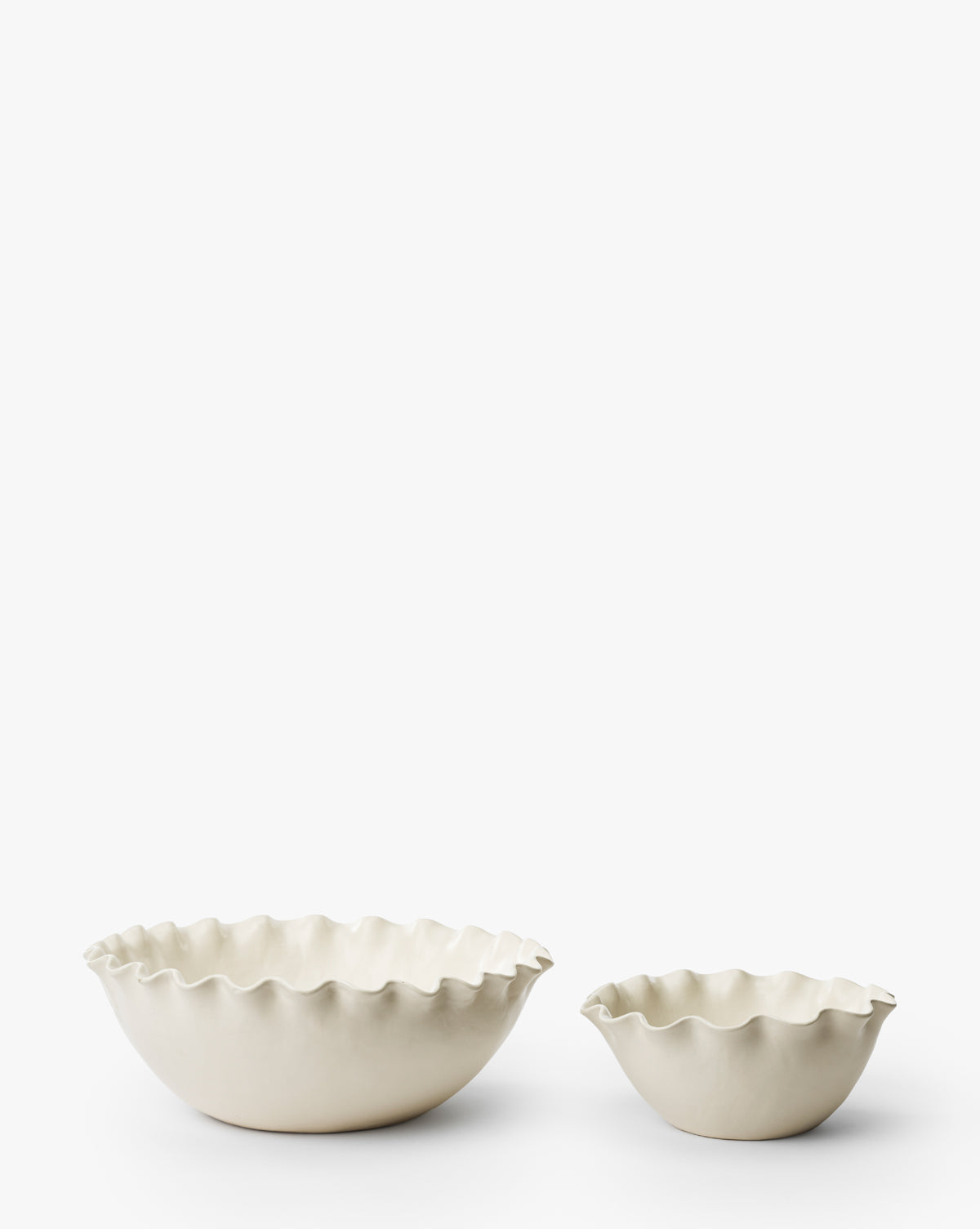 The Olindo Serving Bowls (Set of 2), featuring ivory coloring and wavy ruffled edges in two sizes, are displayed on a plain white background, bringing a vintage-inspired accent to your stoneware collection, by McGee & Co.