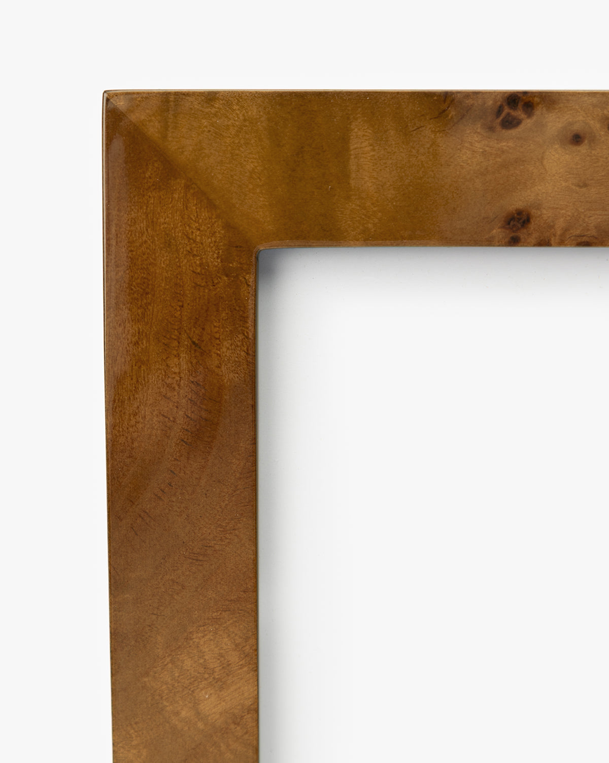 Close-up of the top left corner of an Oliver Burl 4x6 Frame (Set of 2), featuring a smooth, polished finish and natural grain patterns—an ideal accent to elevate your home decor against a crisp white background, by McGee & Co.