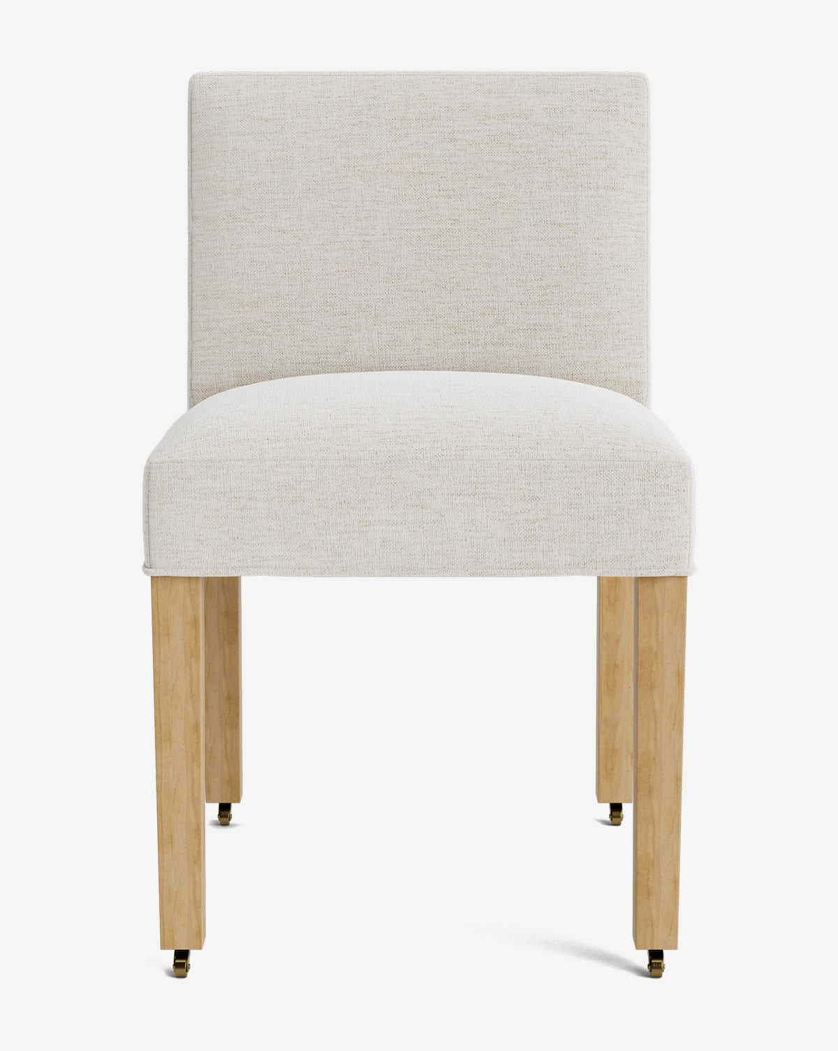 The Olivier Upholstered Dining Chair features a cream fabric seat and back, set on four light wood legs with brass casters, by McGee & Co. It is photographed against a plain white background.