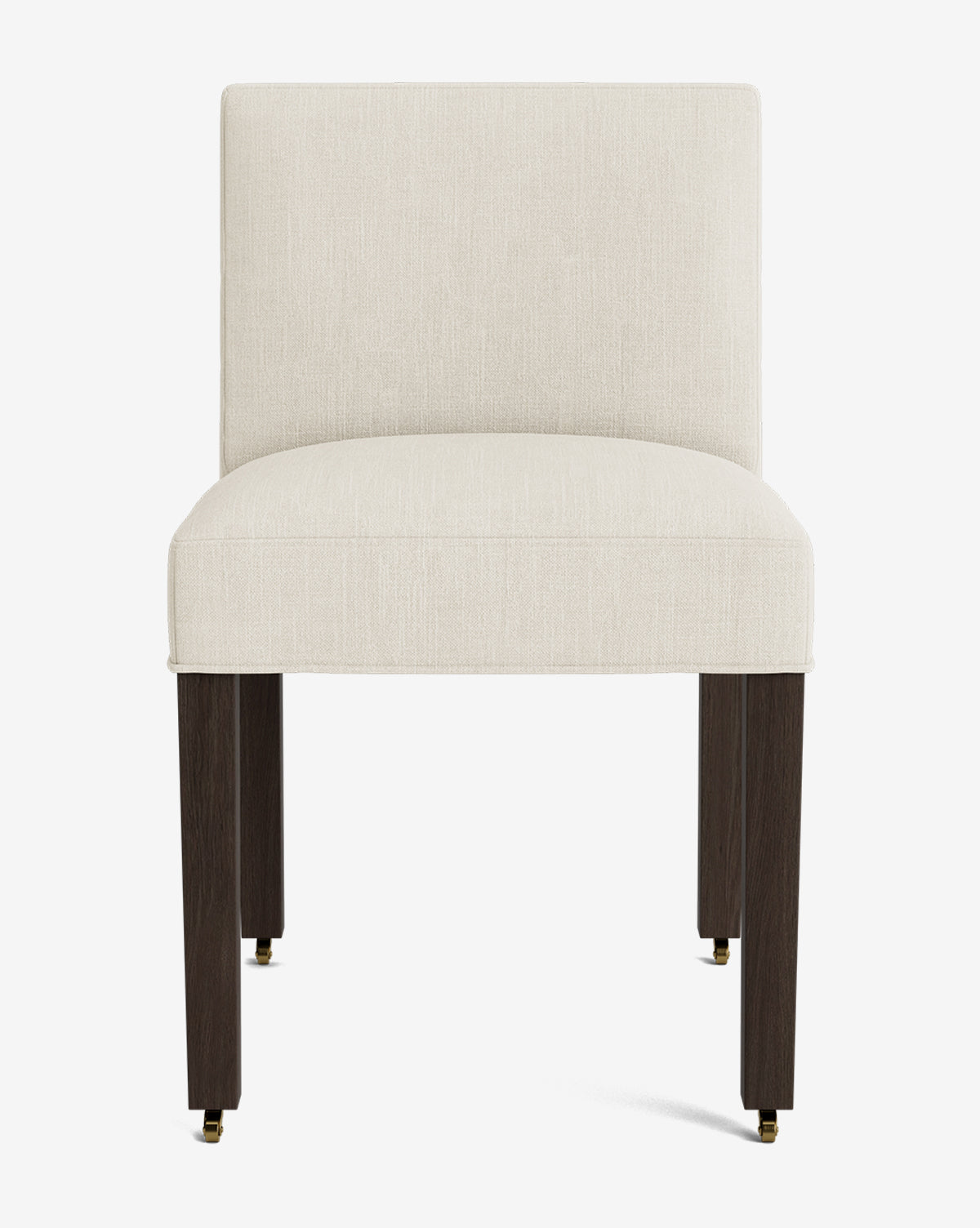 The Olivier Upholstered Dining Chair features a modern armless design with a cream fabric seat and backrest, supported by four dark wooden legs and small brass casters on the front legs, by McGee & Co.
