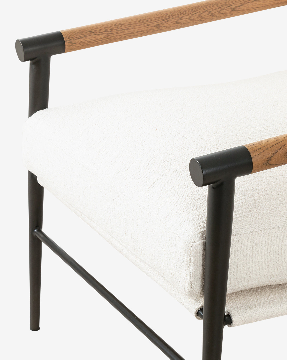 The Ona Lounge Chair features a white upholstered cushion, black metal frame, and wooden armrests. Its clean lines and minimalist design make it ideal for contemporary or industrial-inspired spaces, by McGee & Co.