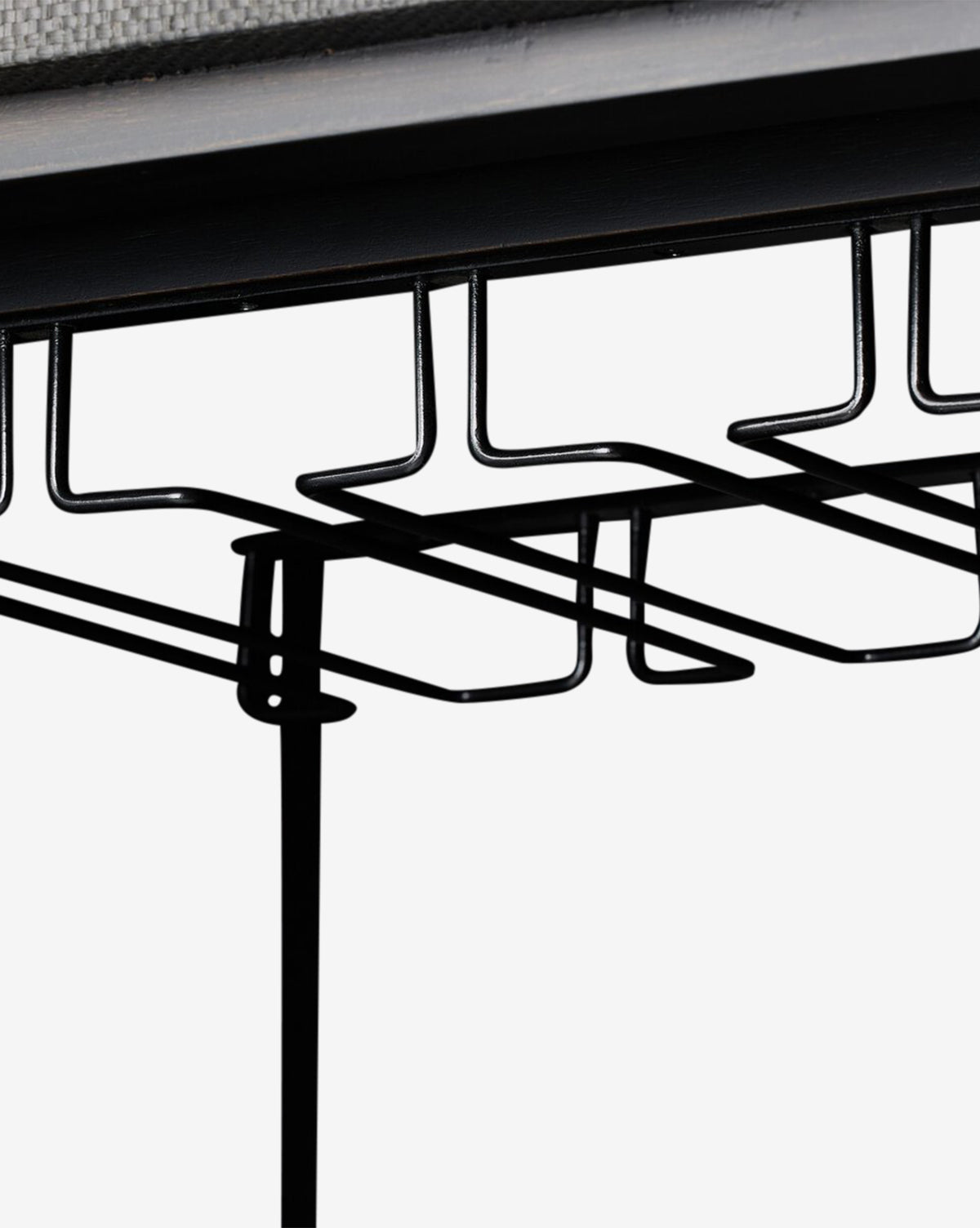 Close-up of a black metal wire under-desk cable tray mounted beneath a desk to organize cables—an ideal complement to the Osborne Cabinet in solid mahogany or black raffia office décor, by McGee & Co.