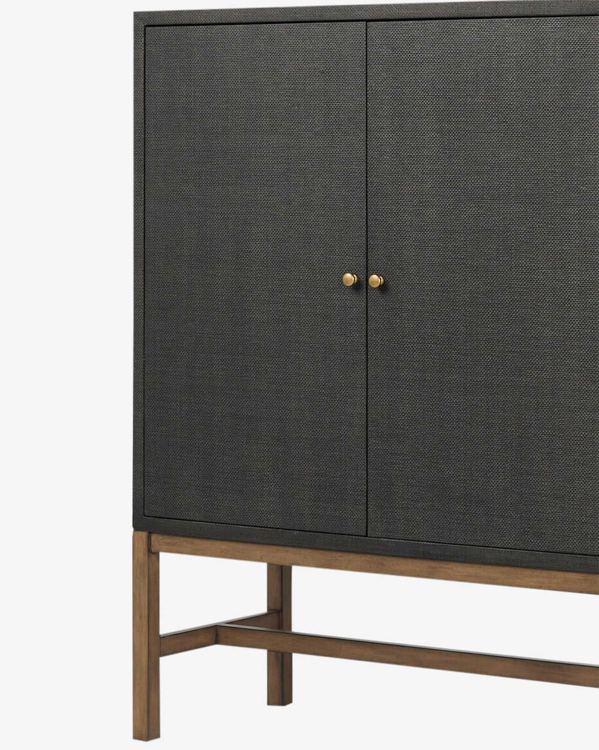 The Osborne Cabinet features modern black raffia, textured dark doors, antique brass hardware, and a solid mahogany base with crossbar supports, displayed against a white background, by McGee & Co.