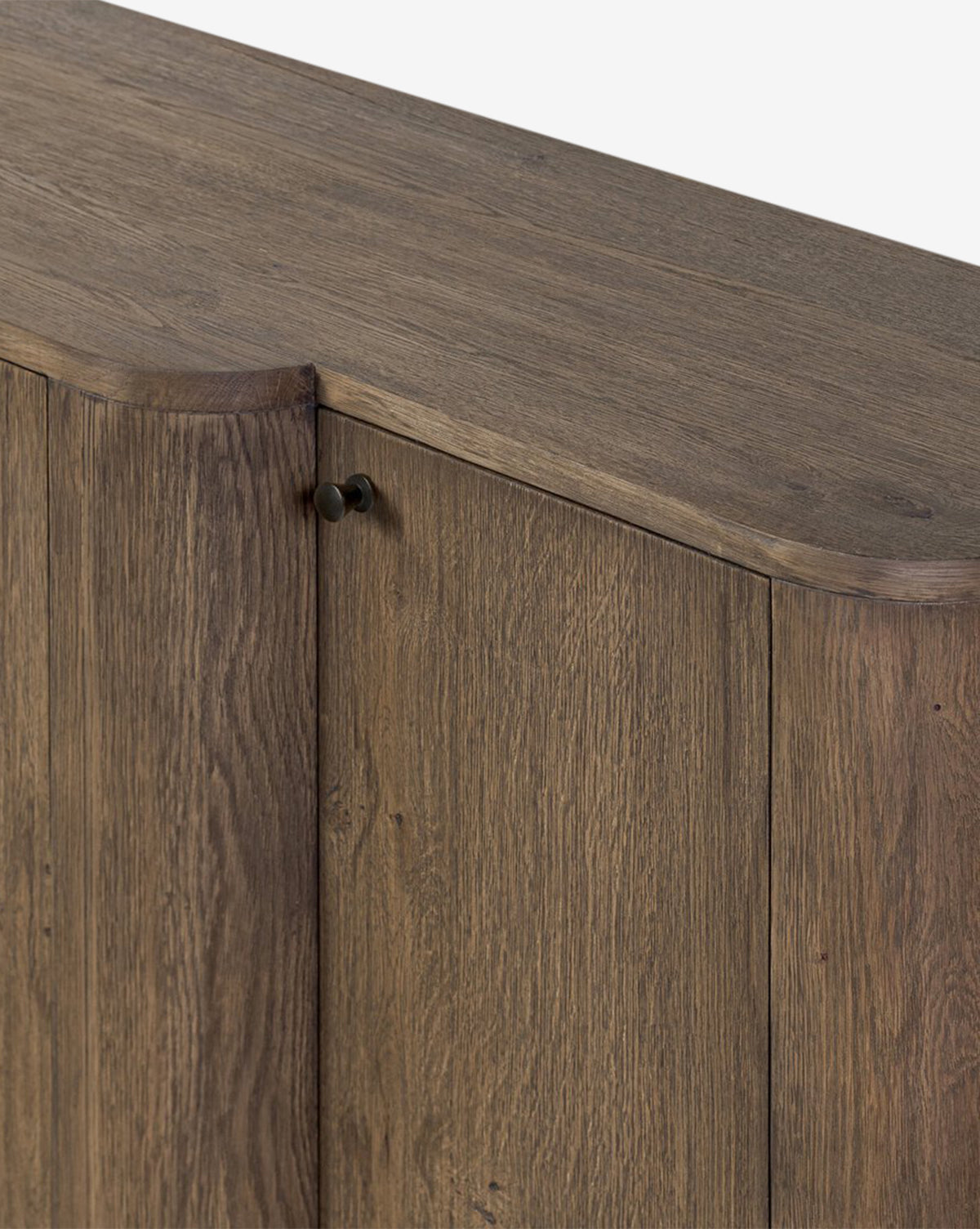 A close-up of the Oswin Sideboard highlights its weathered oak finish, showcased wood grain, beveled top edges, and a door featuring a small round handle, by McGee & Co.