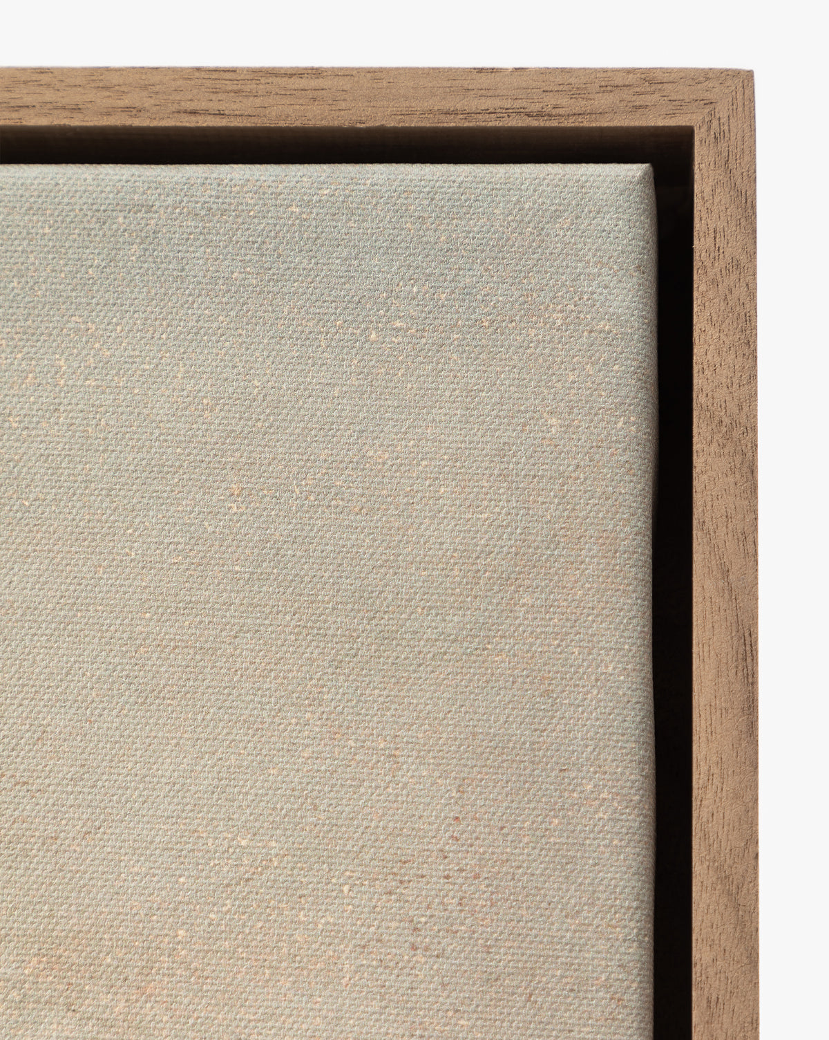 Close-up of the beige textured fabric of Overlook stretched on canvas, partially framed with wood and corner visible in the upper right—a striking detail in this museum-quality wall art, by McGee & Co.