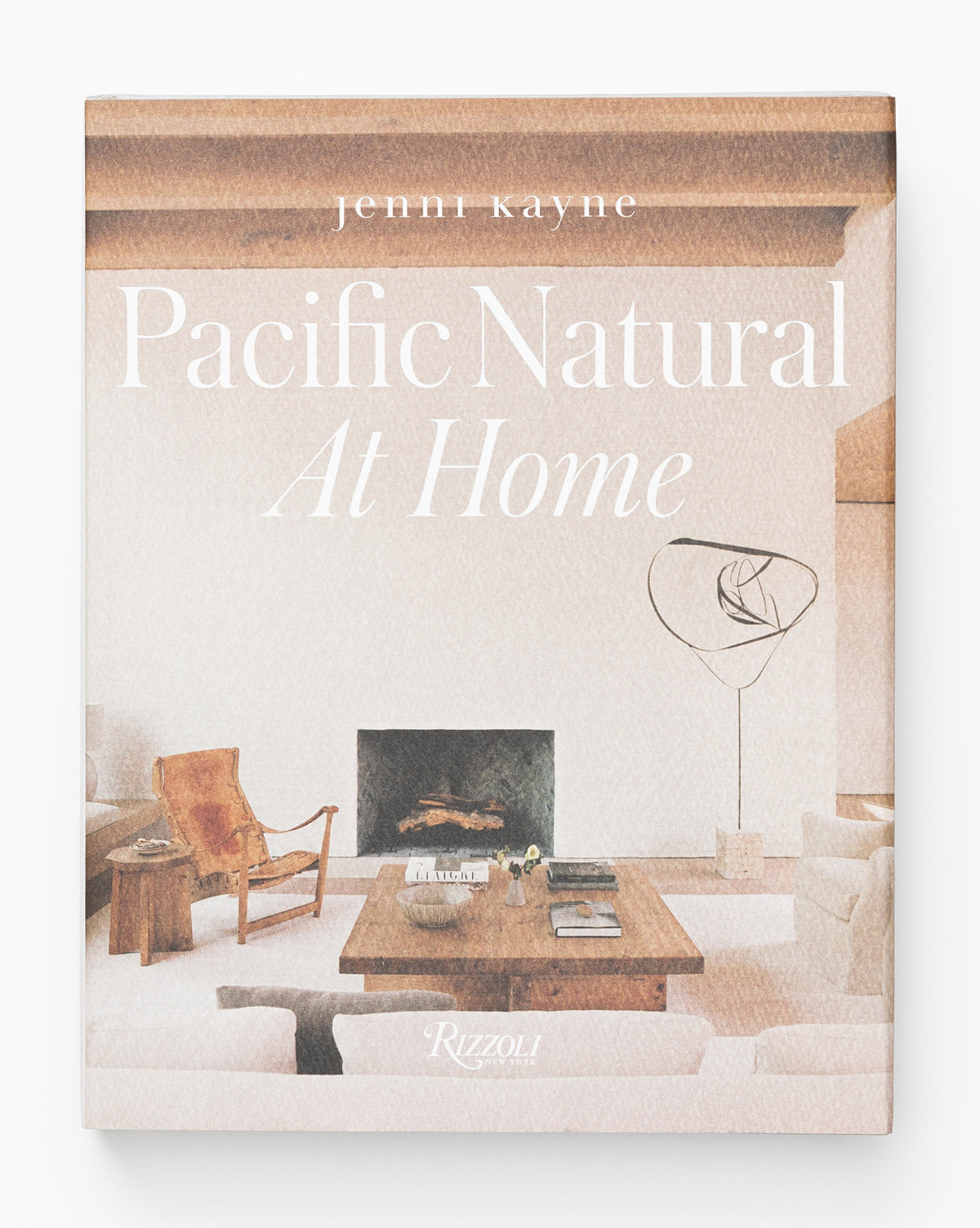 The cover of Pacific Natural at Home features a serene, minimalist living room with neutral tones, wooden beams, and modern furniture, capturing the elegant and calming style of west coast interiors.