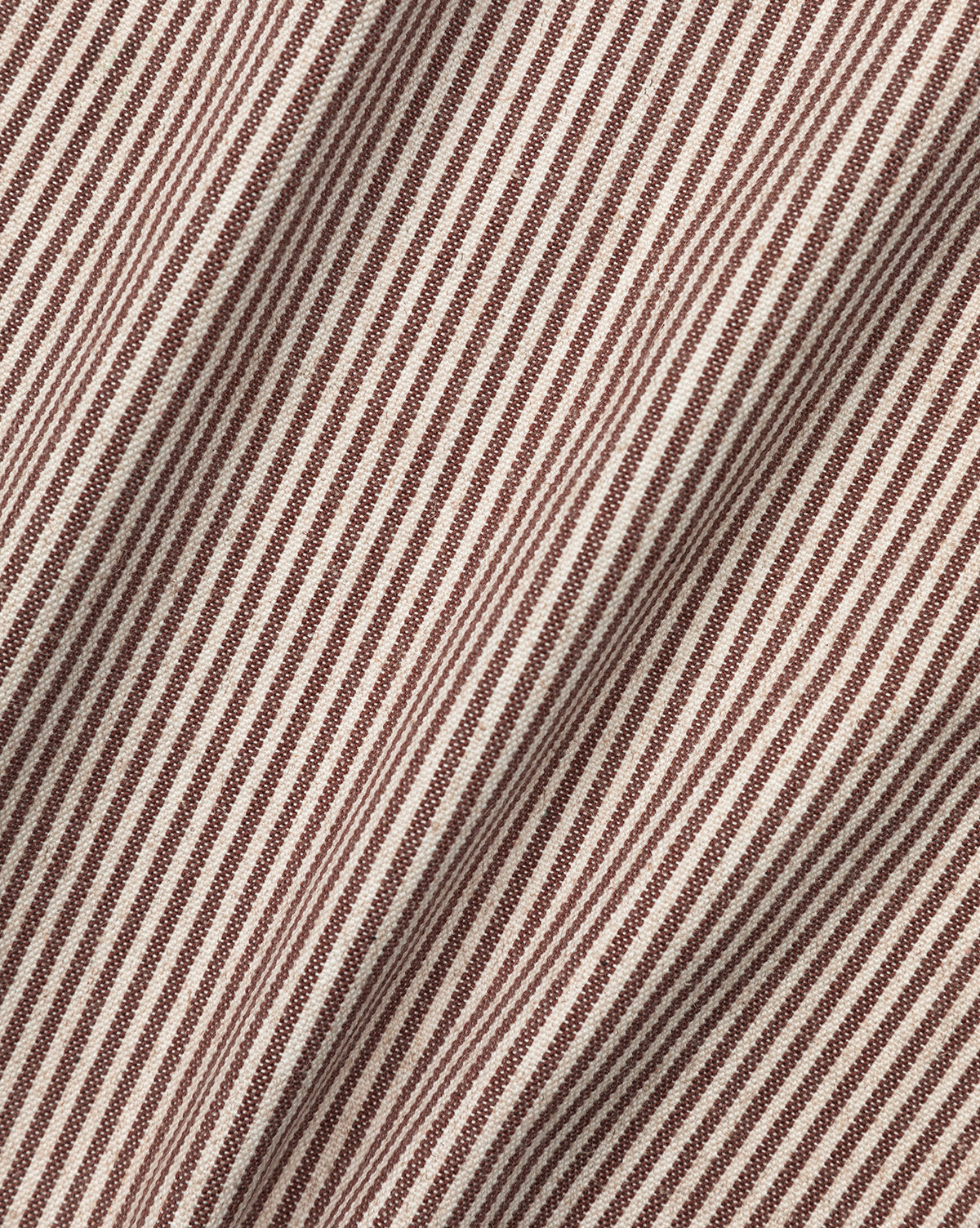 Close-up of Makerspalm Palladio Bed Brown & Ivory Classic Swatch fabric, featuring diagonal brown and ivory ticking stripes with visible folds and texture—ideal for adding depth and movement to an upholstered headboard. McGee & Co.