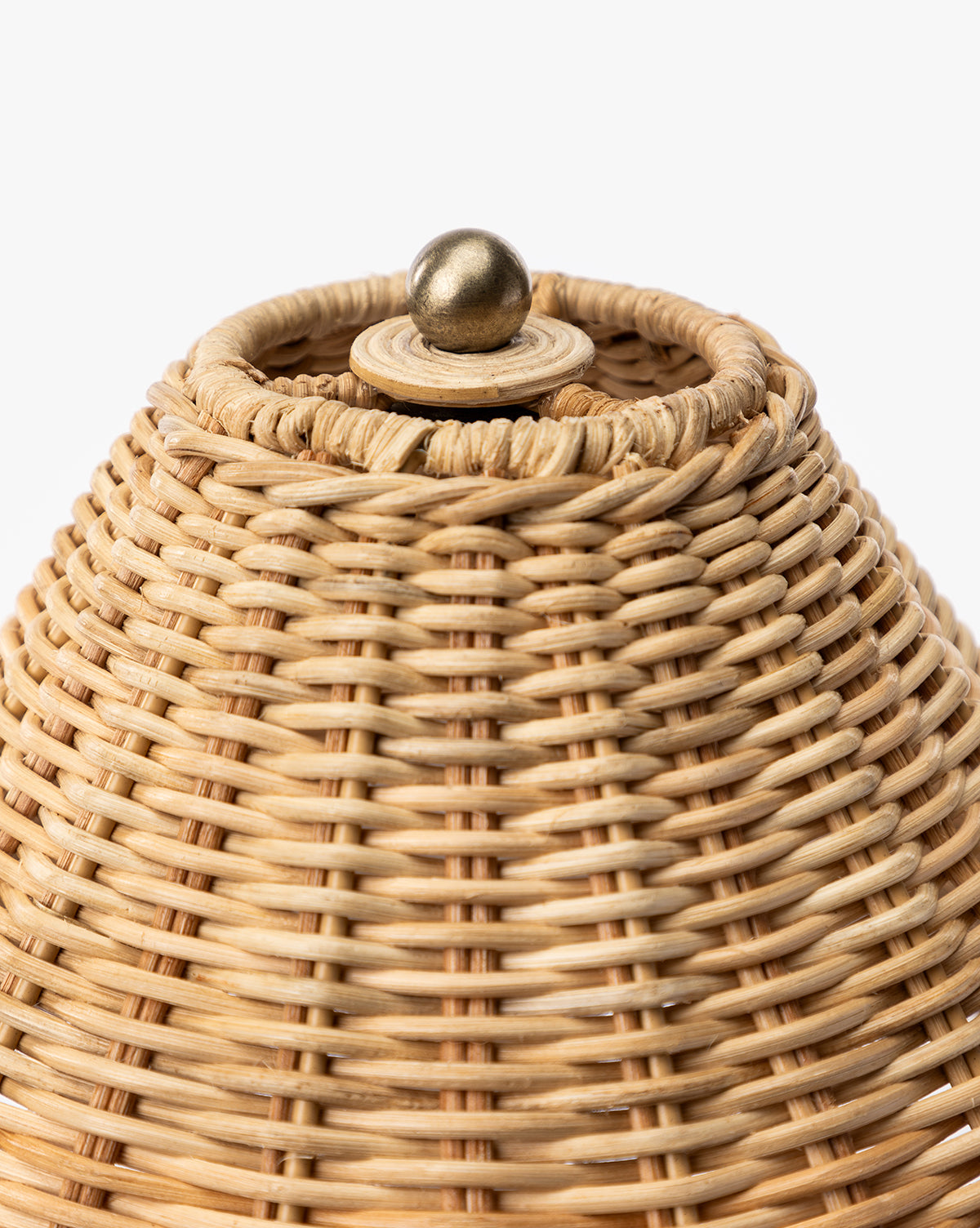 Close-up of the top of the Palmetto Table Lamp, showing its round brass knob on the woven wicker lid, by McGee & Co.