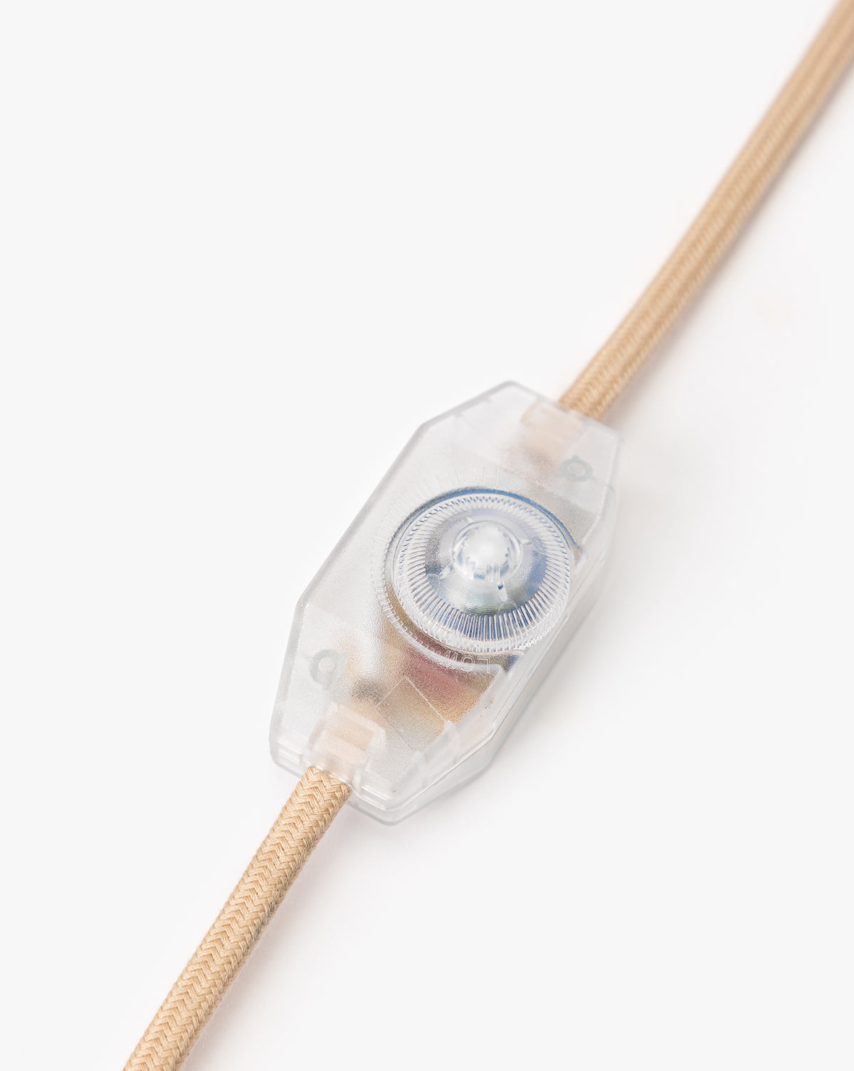 A close-up of a transparent inline rotary switch on the beige fabric cord of the Palmetto Table Lamp, ideal for dimming, shown against a white background, by McGee & Co.