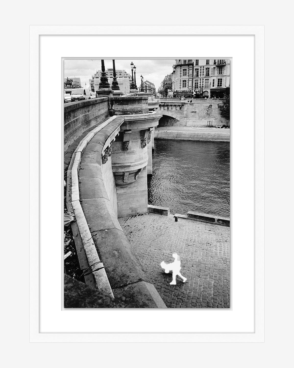 Parisian Promenade is a black and white gallery-quality giclee print of a riverside walkway in Europe, featuring an empty stone path along the water and a silhouetted white cartoon-style figure by McGee & Co.