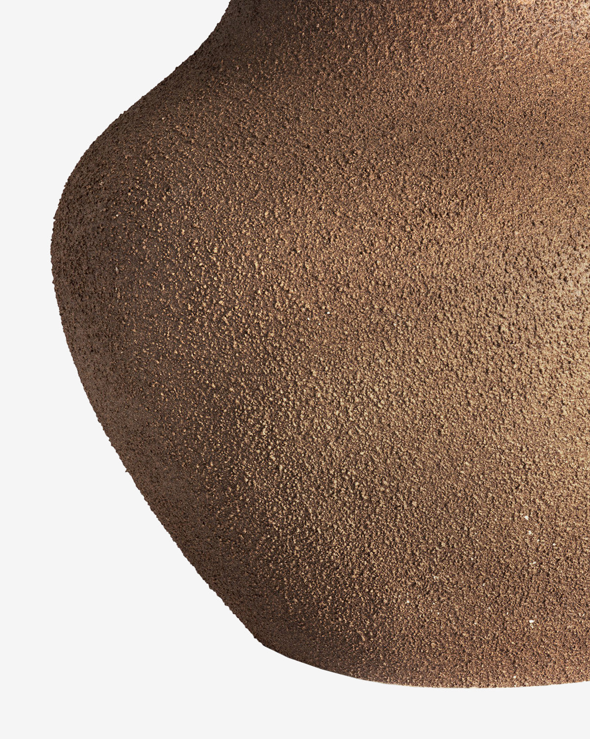 Close-up of the Parma Table Lamp’s ceramic base, showcasing its textured brown, grainy surface and curved shape against a plain white background, by McGee & Co.