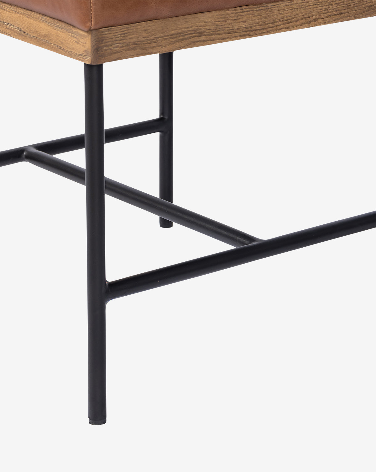 Close-up of the Pascal Dining Chairs leg, featuring a sturdy steel and wood design with a black metal frame and light brown leather seat cushion, ideal as an accent by your dining table, by McGee & Co. Set against a white background.